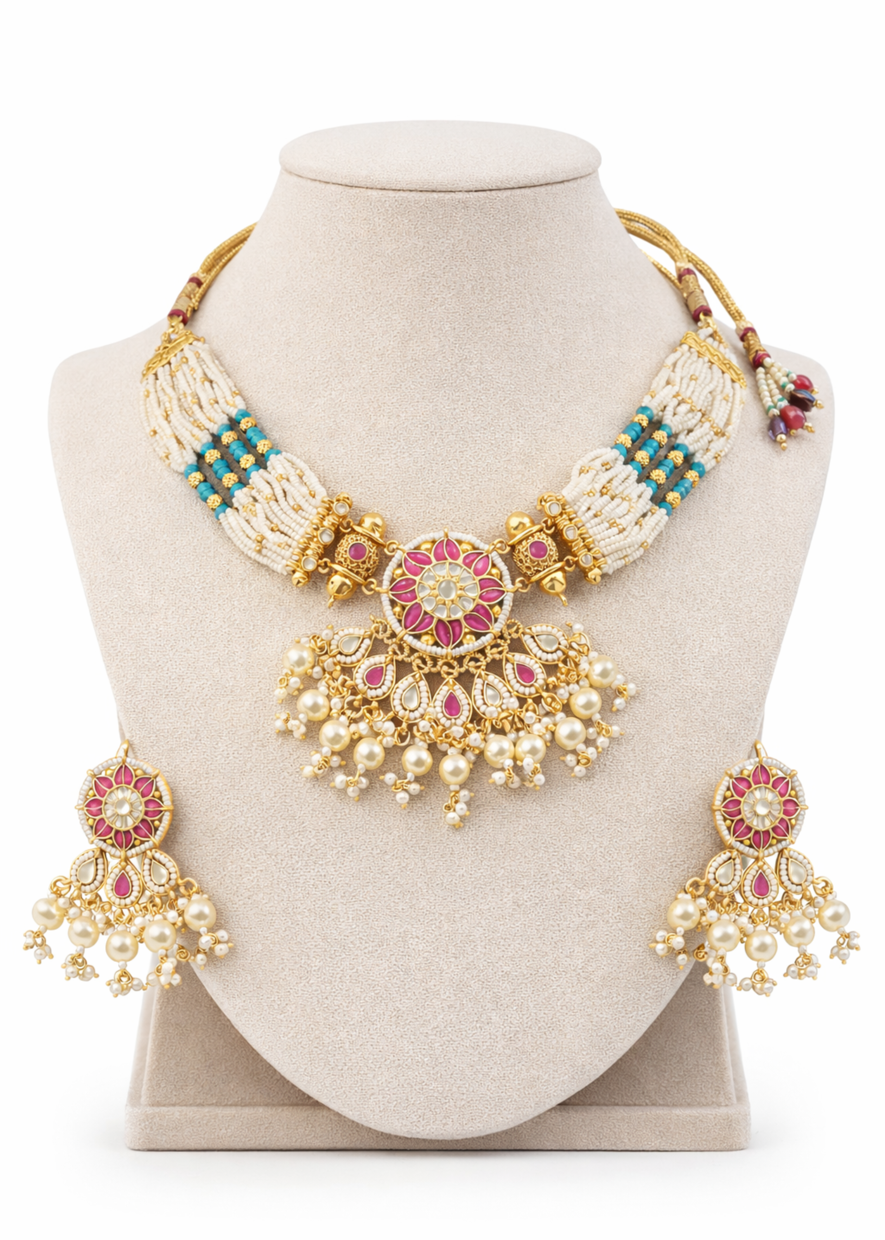 Ornate necklace and earrings set on a mannequin bust with a white background