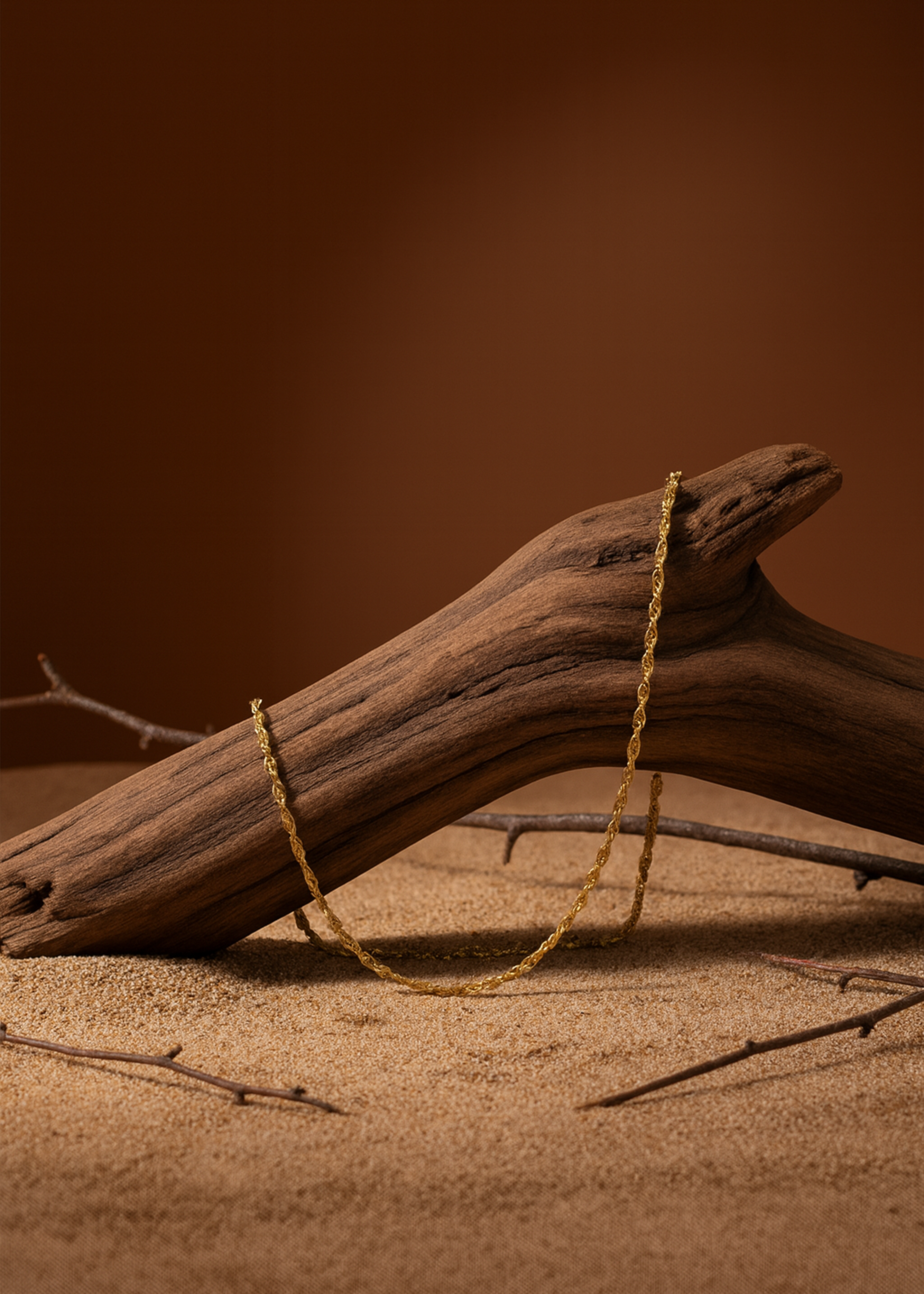 Driftwood with twine on a sandy surface with a brown background