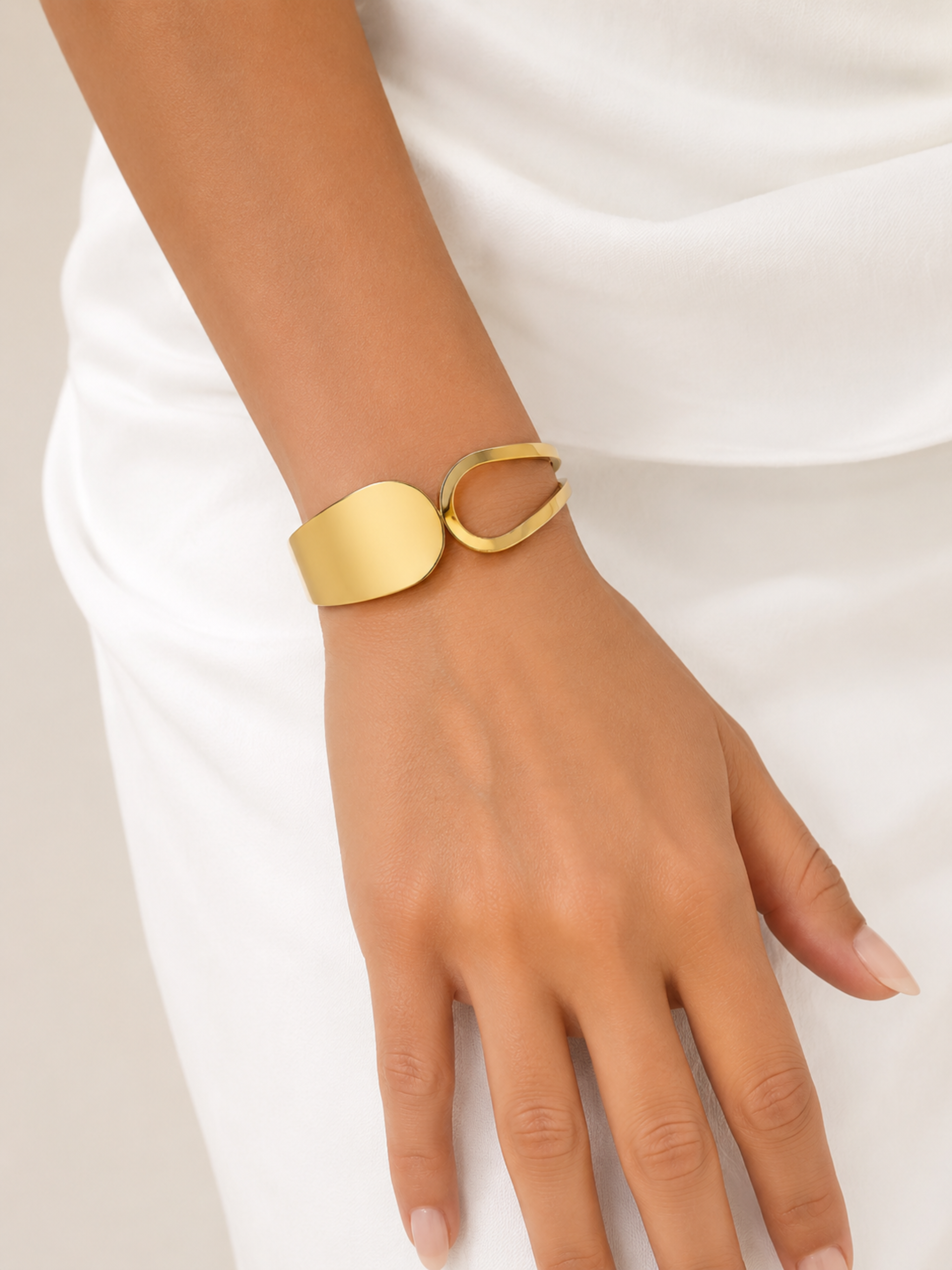Gold bracelet on a wrist against a white background