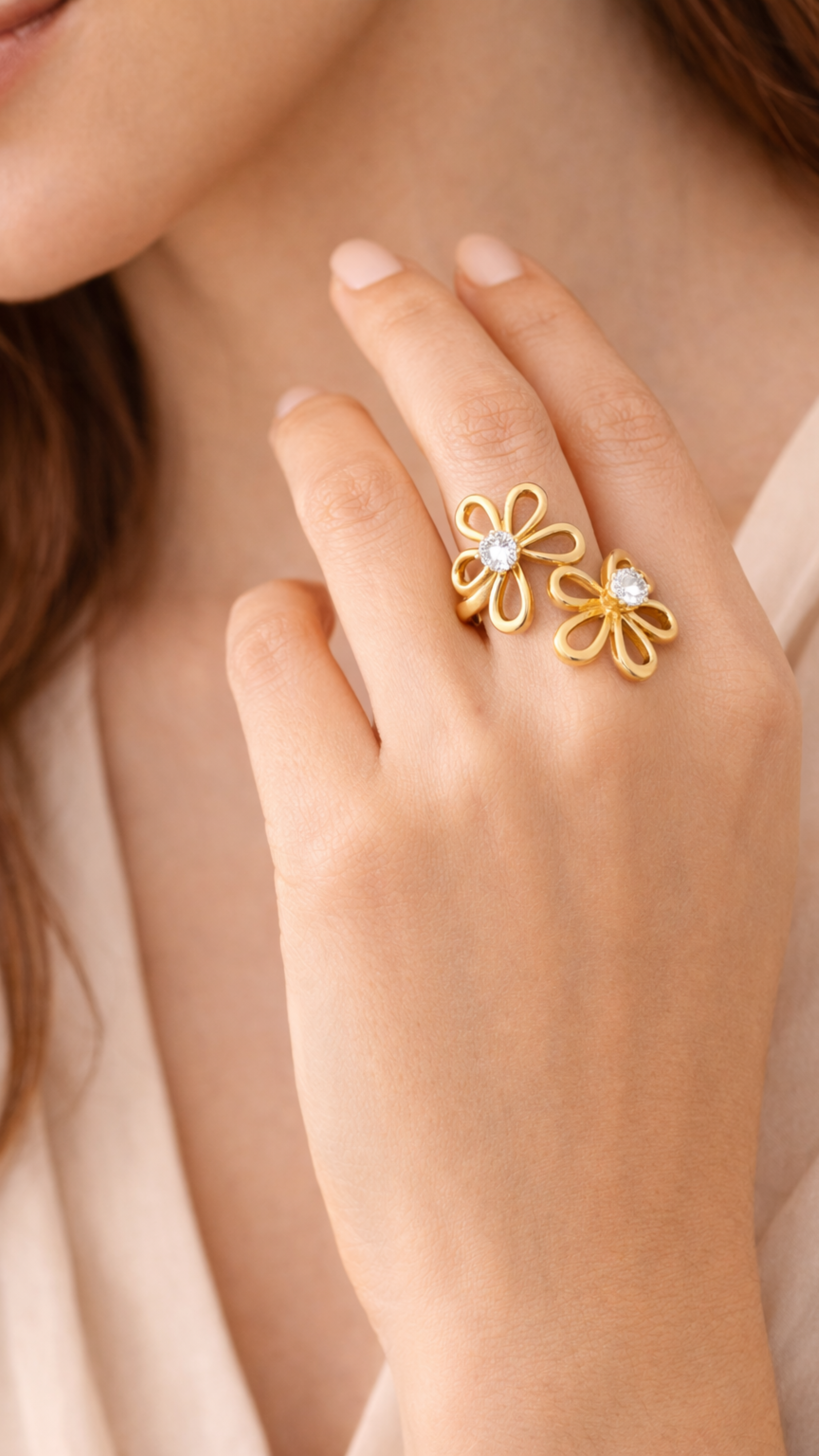 Gold flower-shaped ring on a hand with a soft background