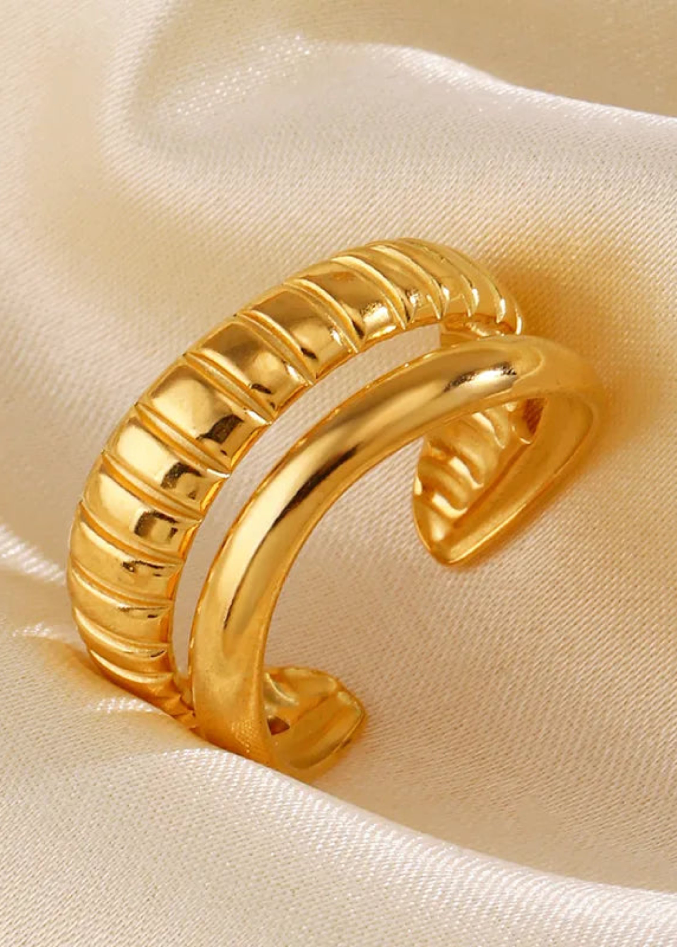 Gold bangle on a beige fabric background