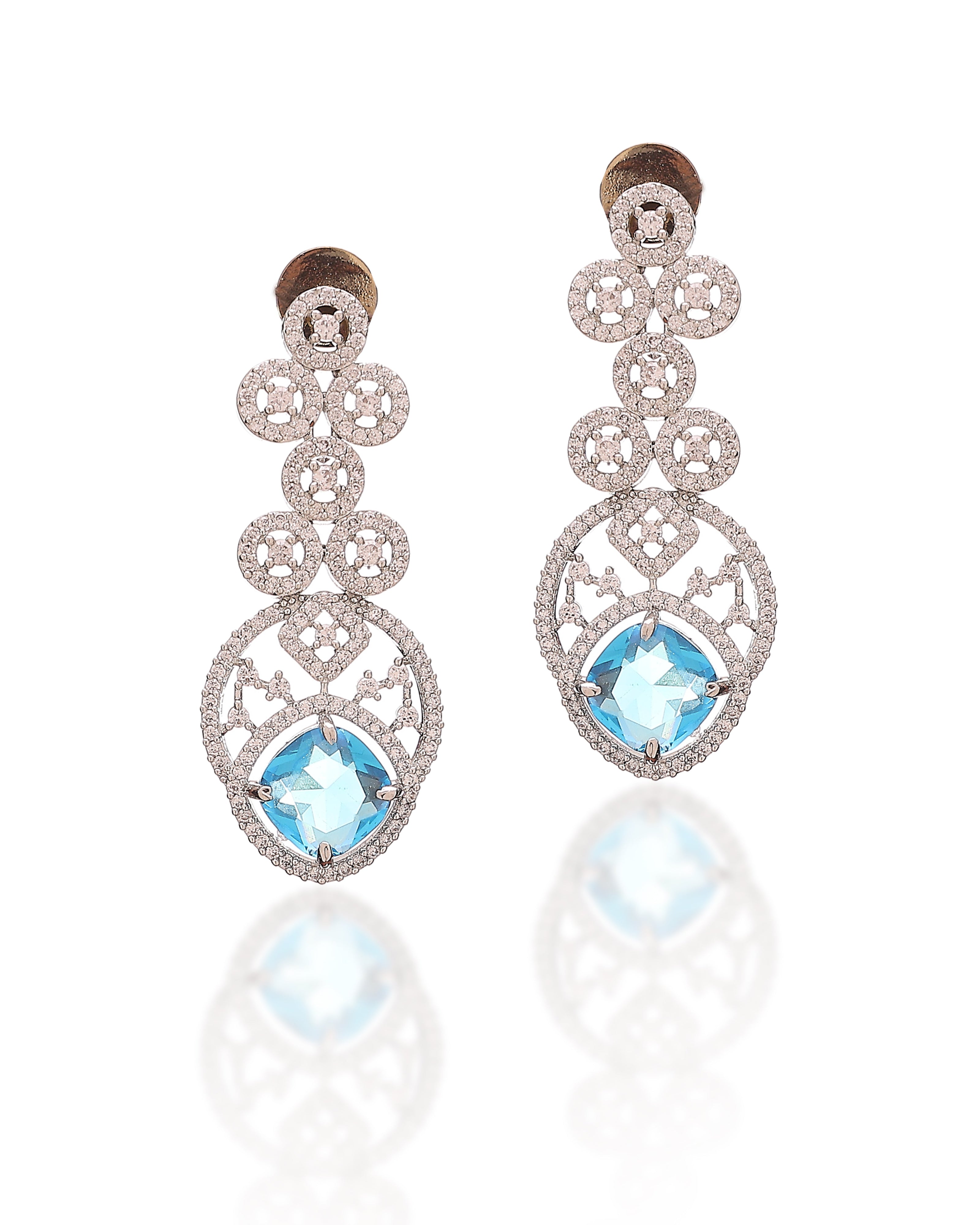 Ornate earrings with blue gemstones on a white background