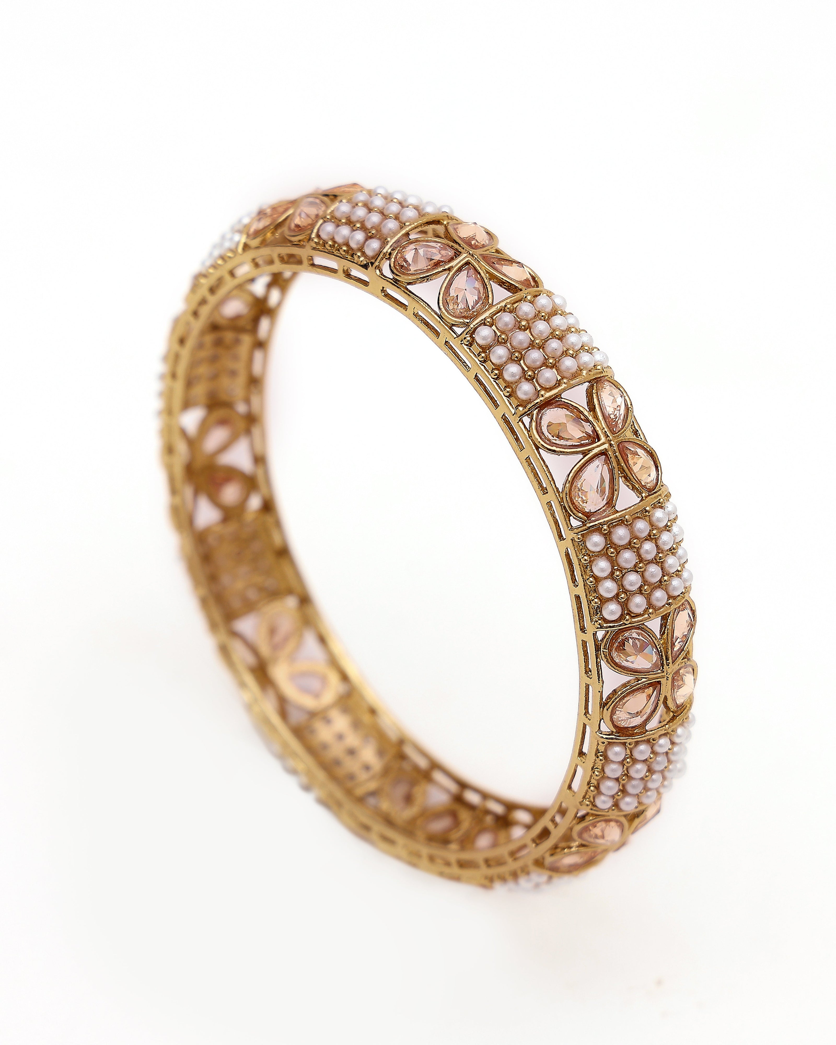 Decorative gold bangle with pearls on a white background