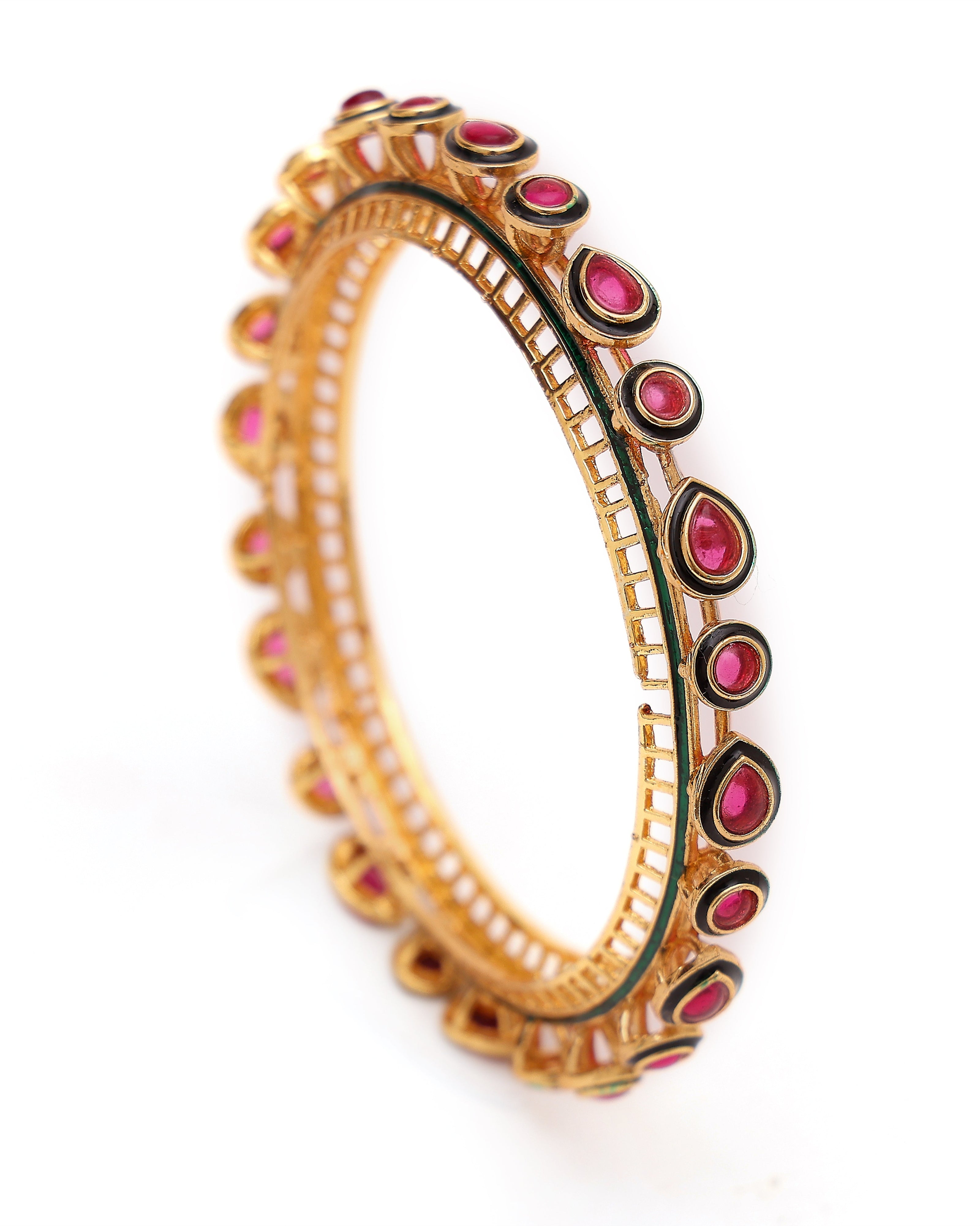 Gold bangle with pink stones on a white background