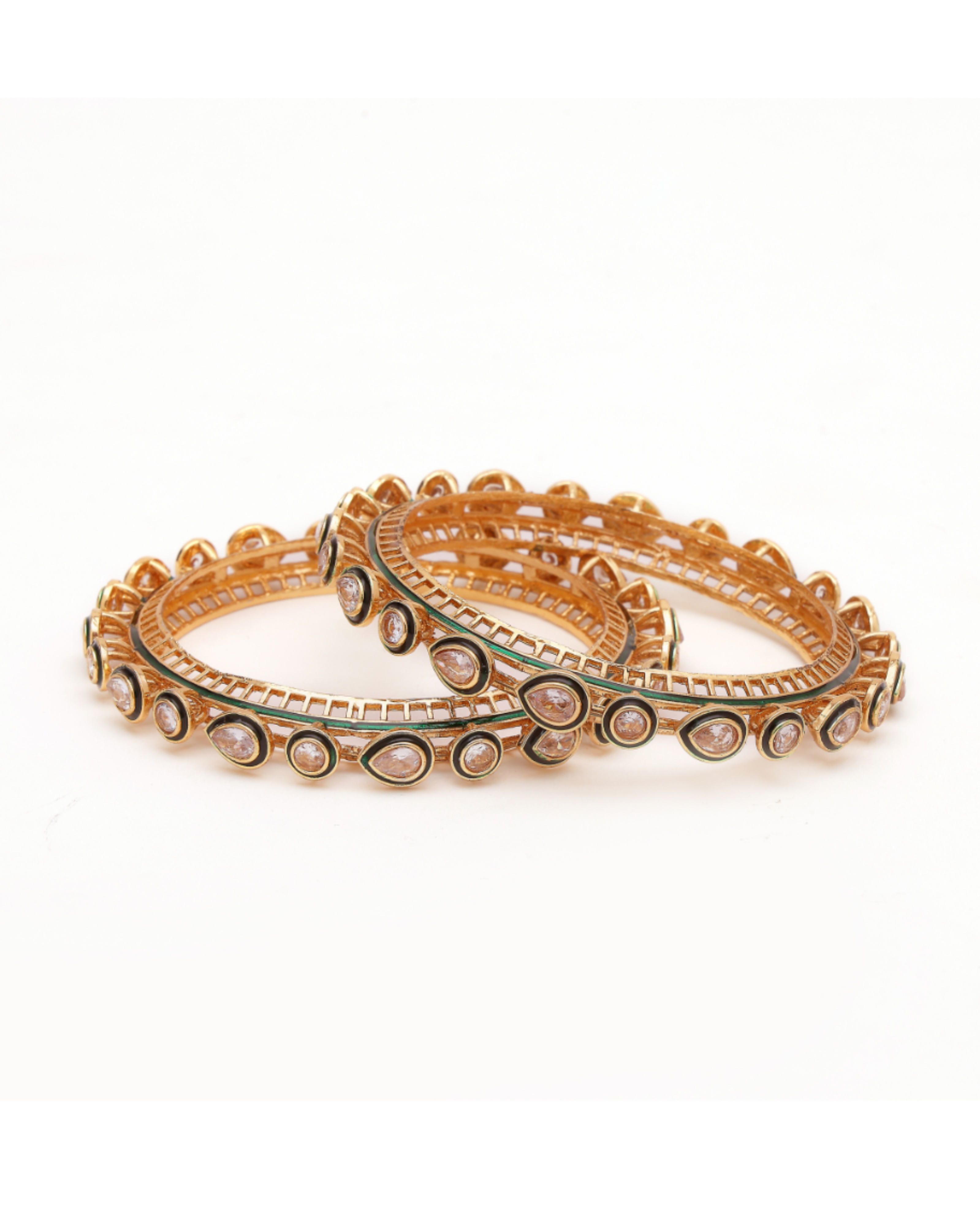 Set of gold bangles with green accents on a white background