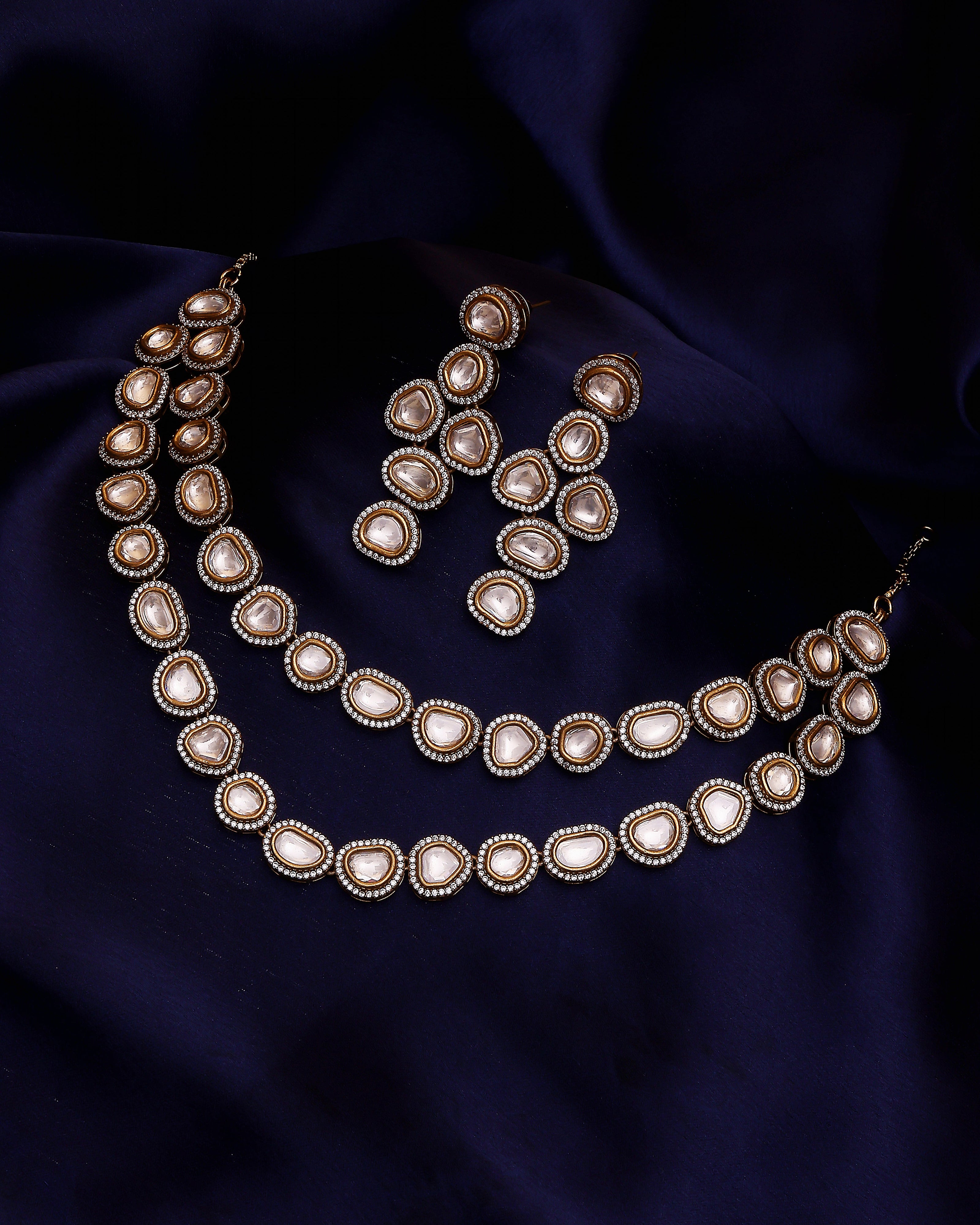 Necklace set with pearls on a dark blue fabric background