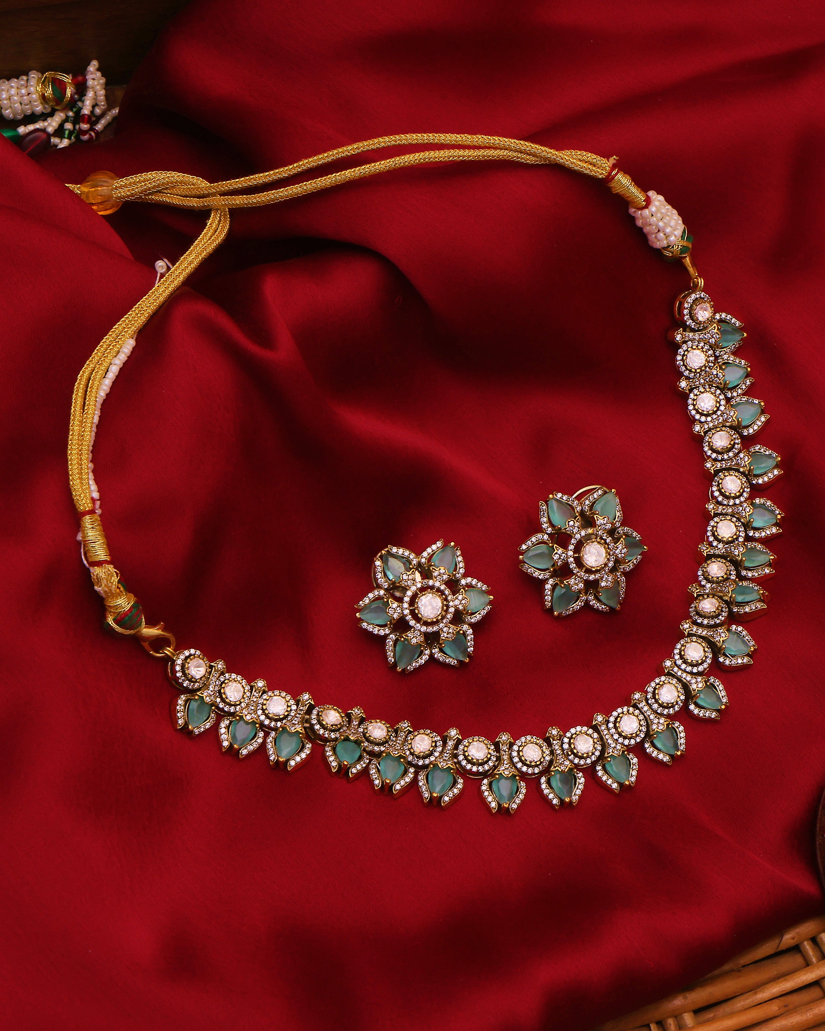 Jewelry set with necklace and earrings on a red fabric background