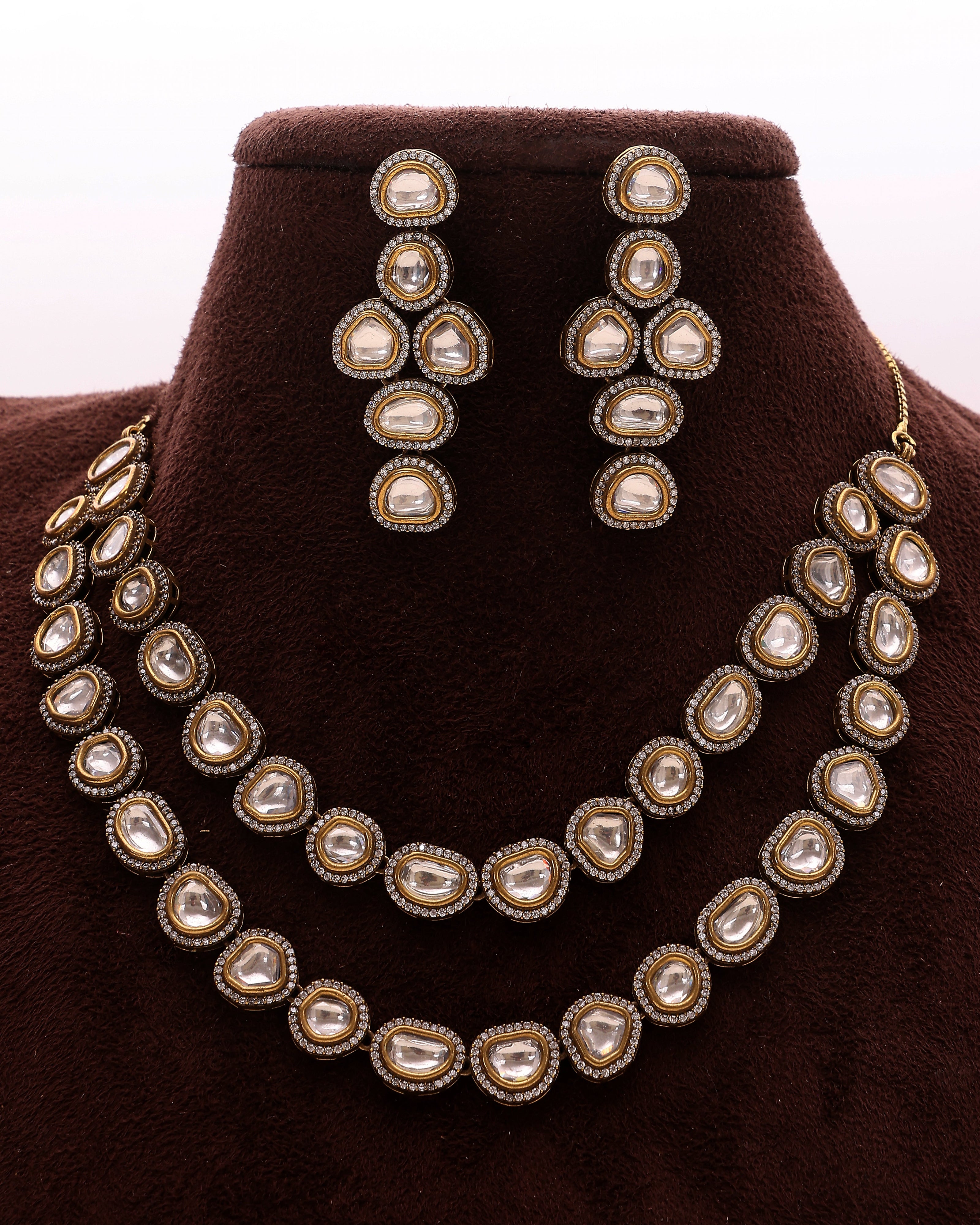 Jewelry set with necklace and earrings on a brown velvet stand