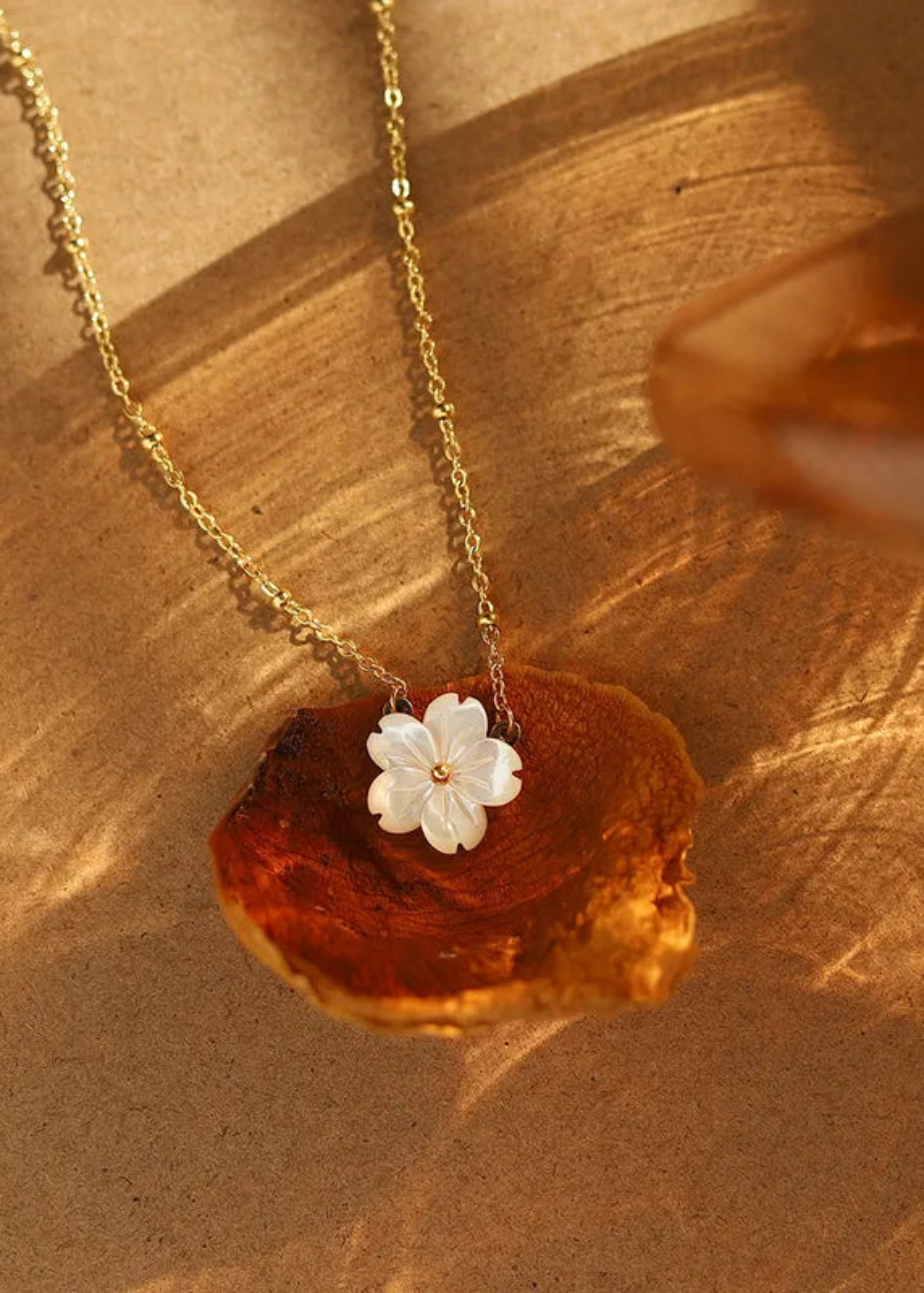 Necklace with a white flower pendant on a piece of amber