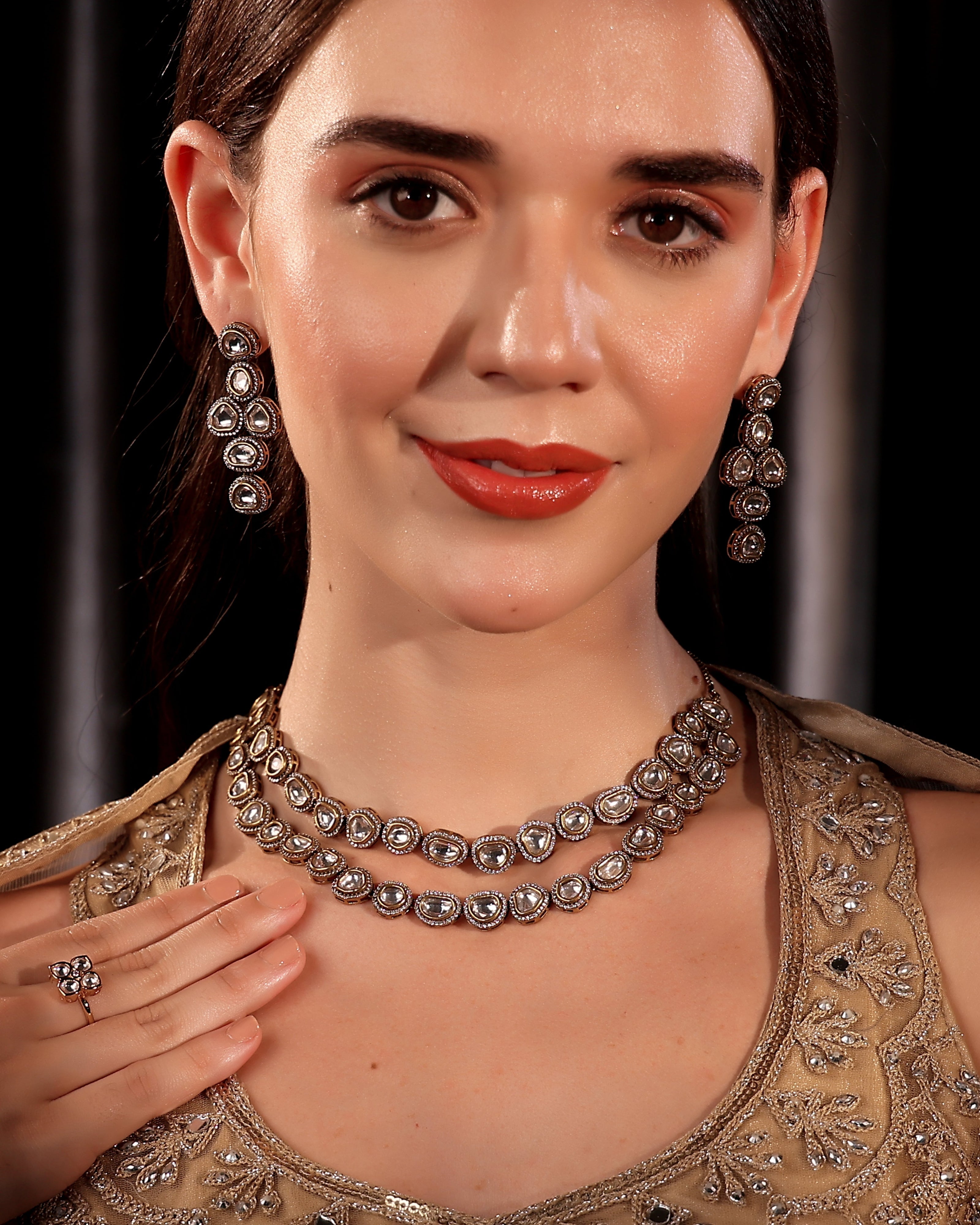 Woman wearing a silver necklace and earrings with a dark background