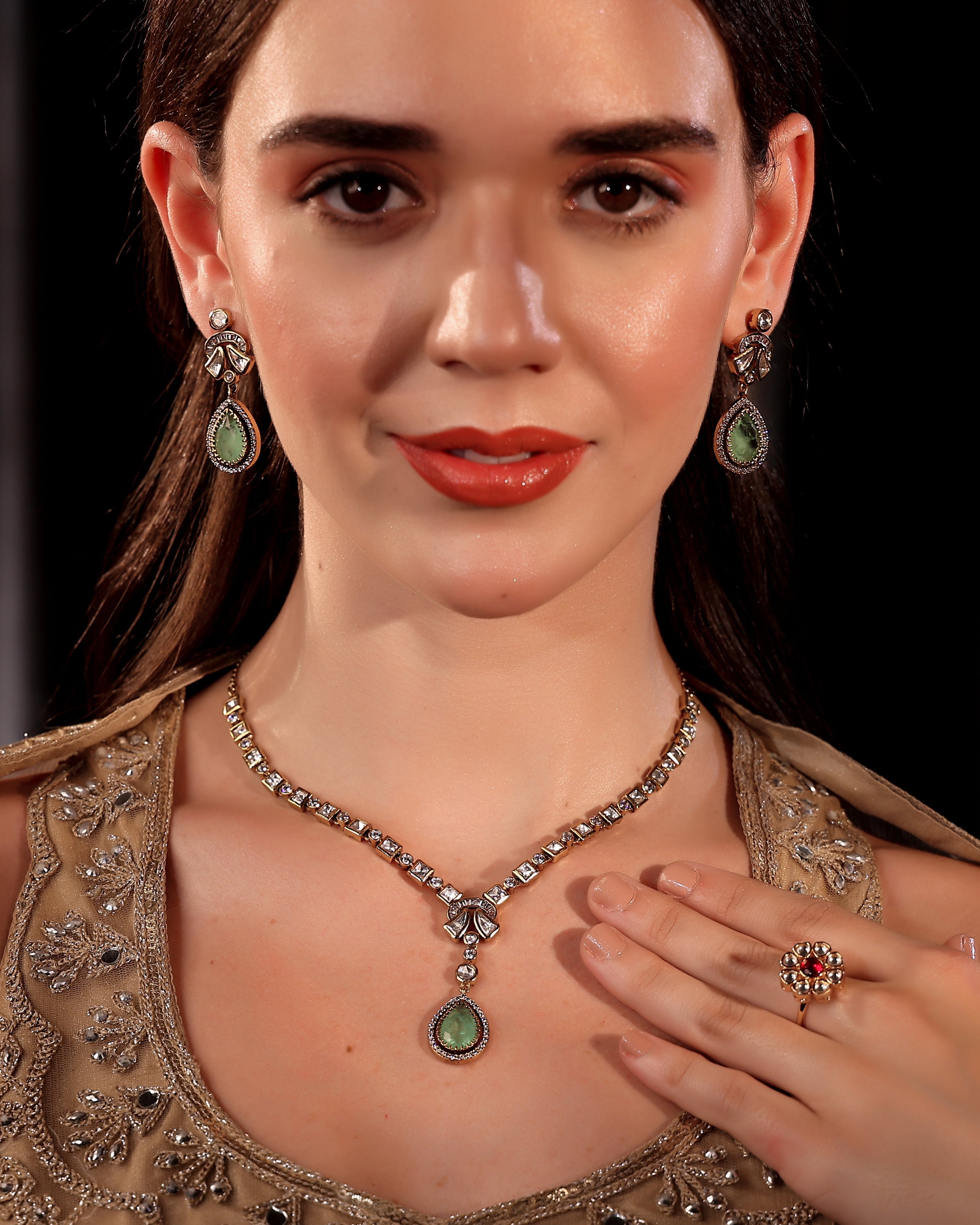 Woman wearing a necklace and earrings with a dark background