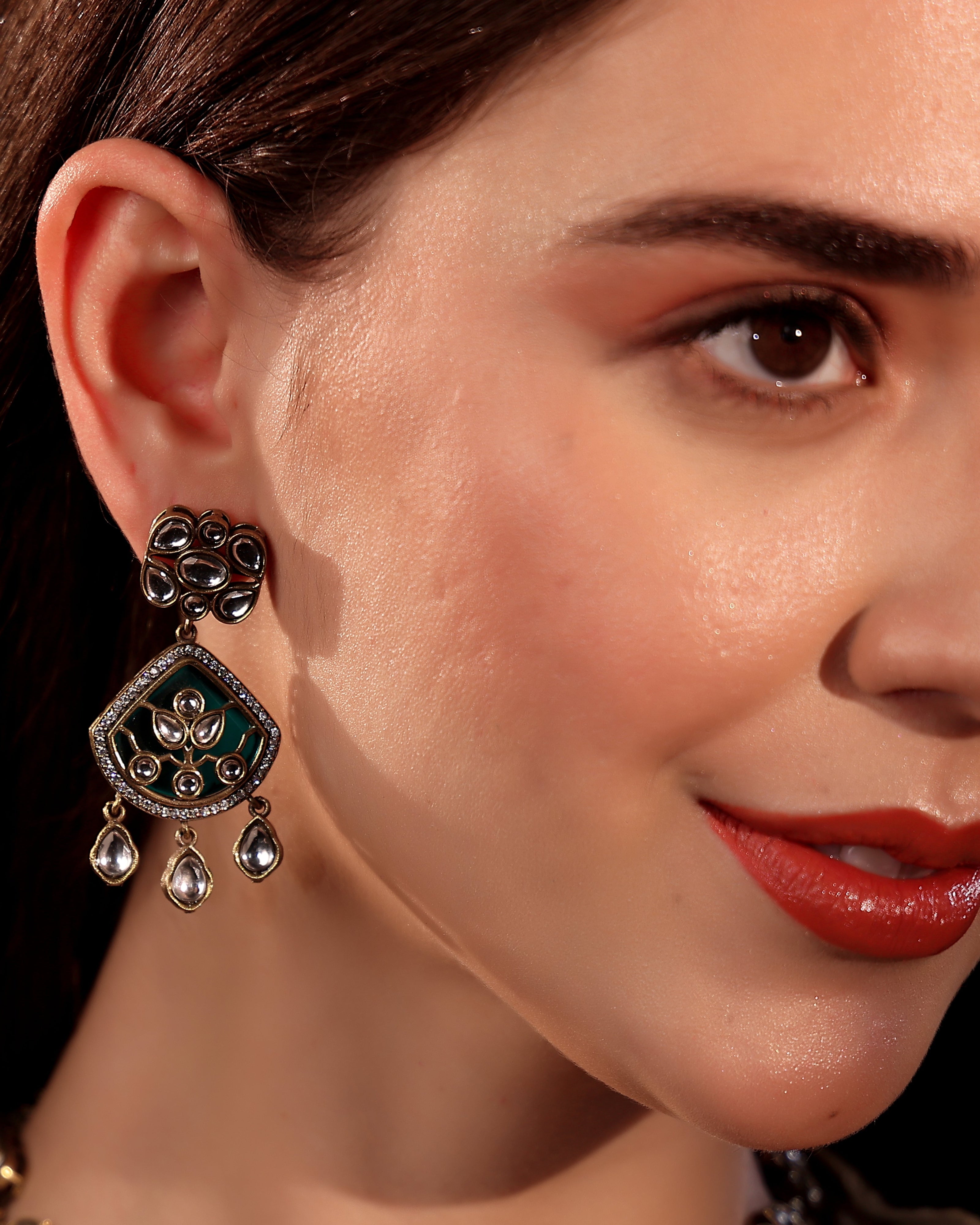 Close-up of a woman wearing an ornate earring with a dark background
