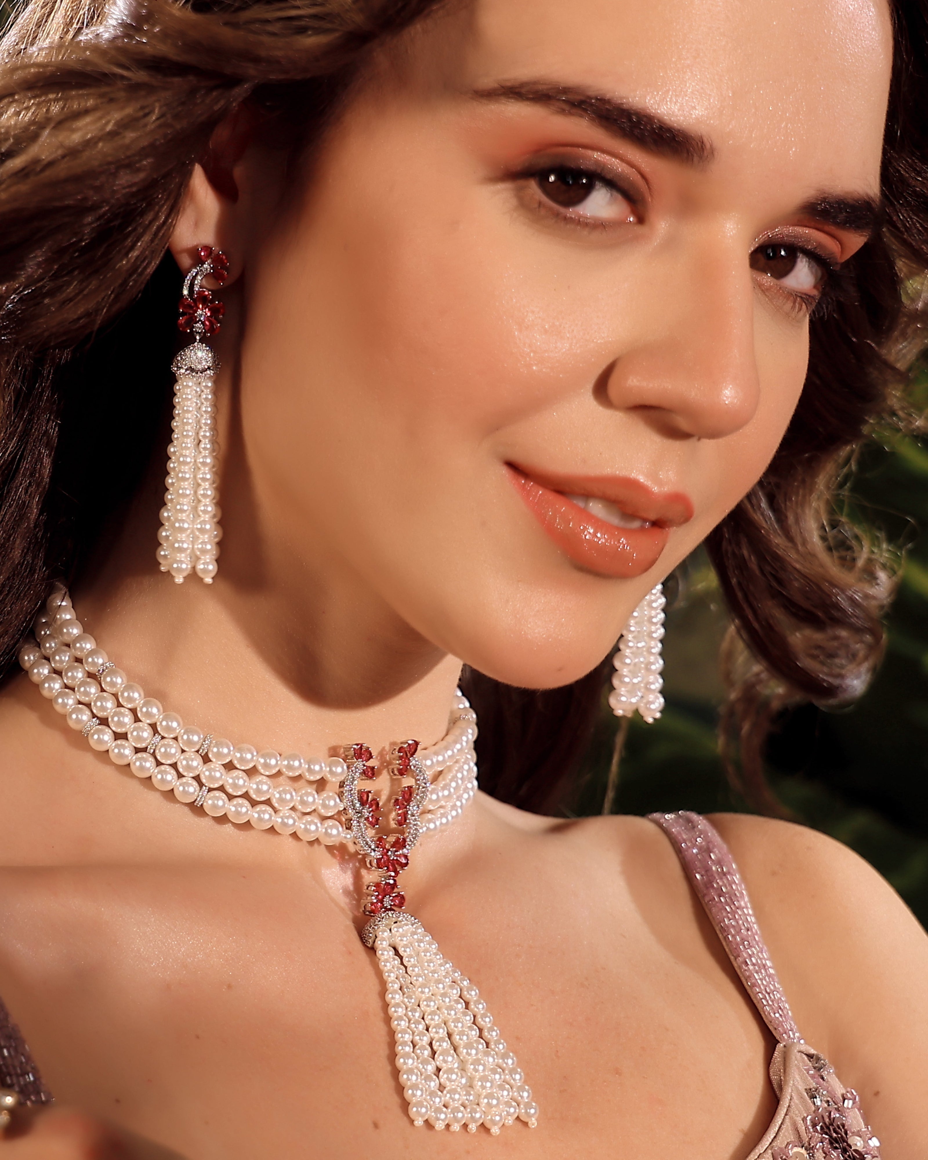 Woman wearing a pearl necklace and earrings with a blurred background