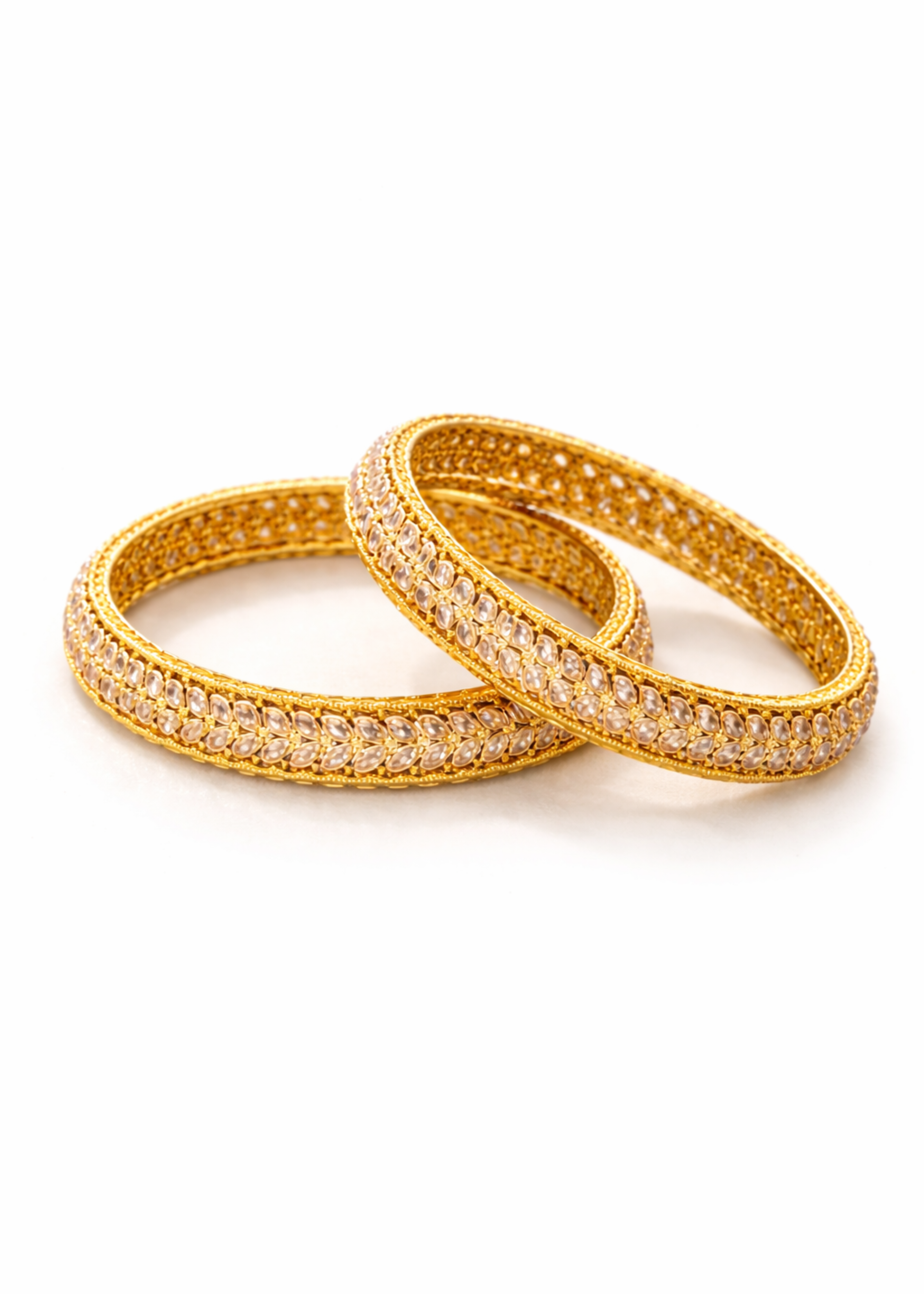 Two gold bangles with gemstones on a white background