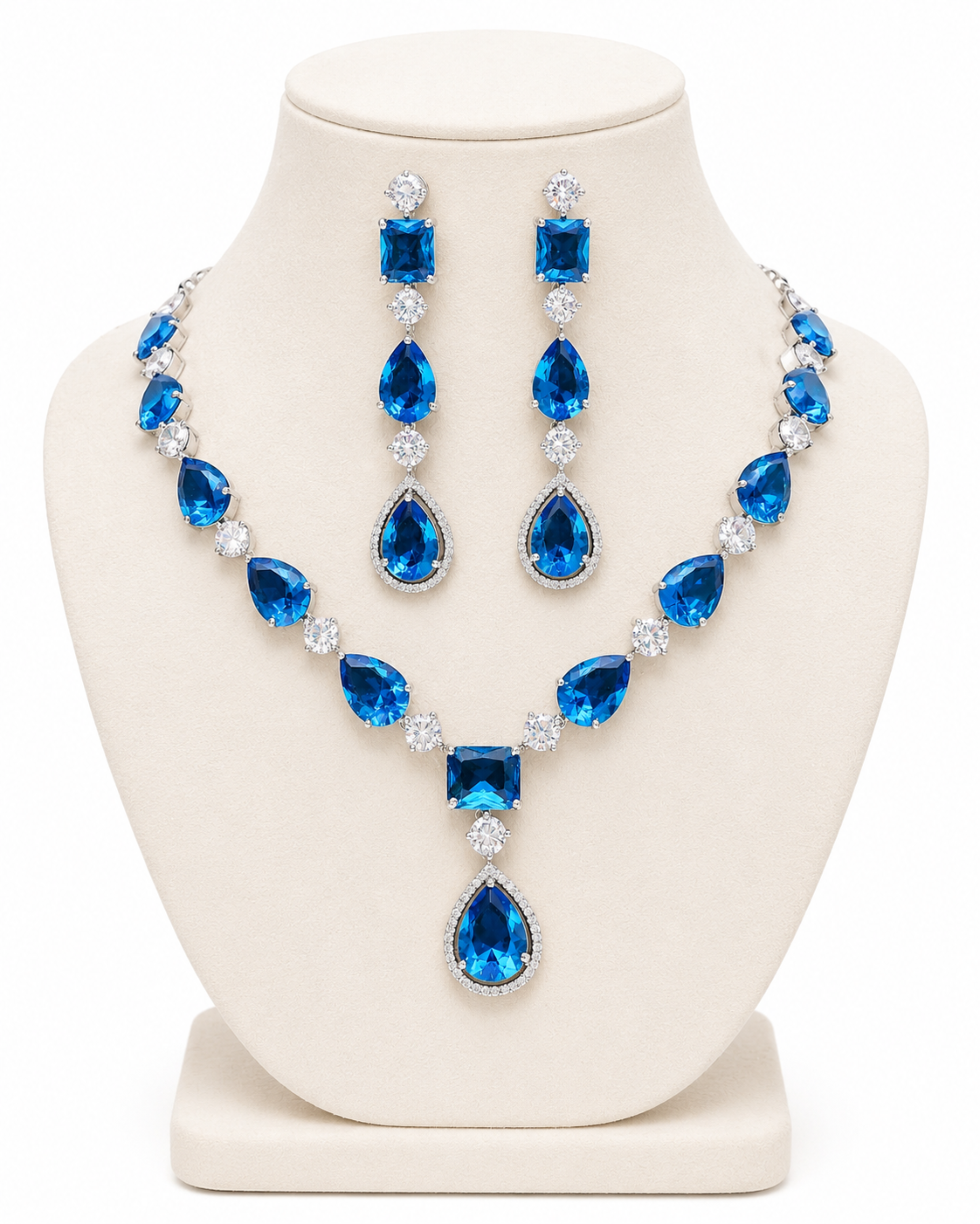 Blue gemstone necklace and earrings set on a white mannequin bust.