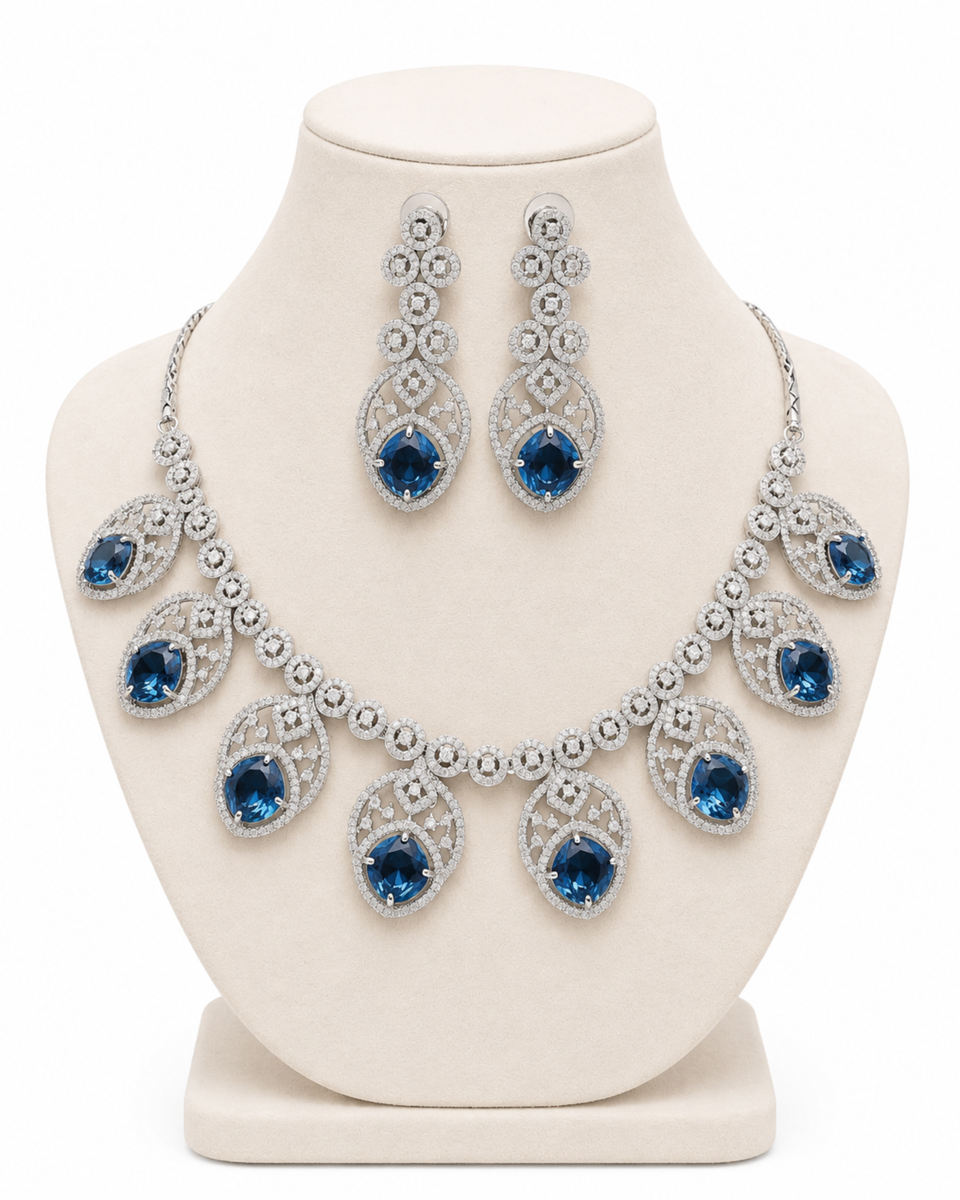 Jewelry set with necklace and earrings featuring blue gemstones on a white mannequin bust.