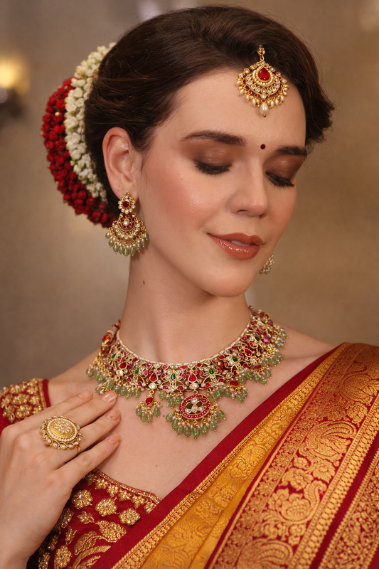 Woman wearing traditional jewelry and a saree with a blurred background