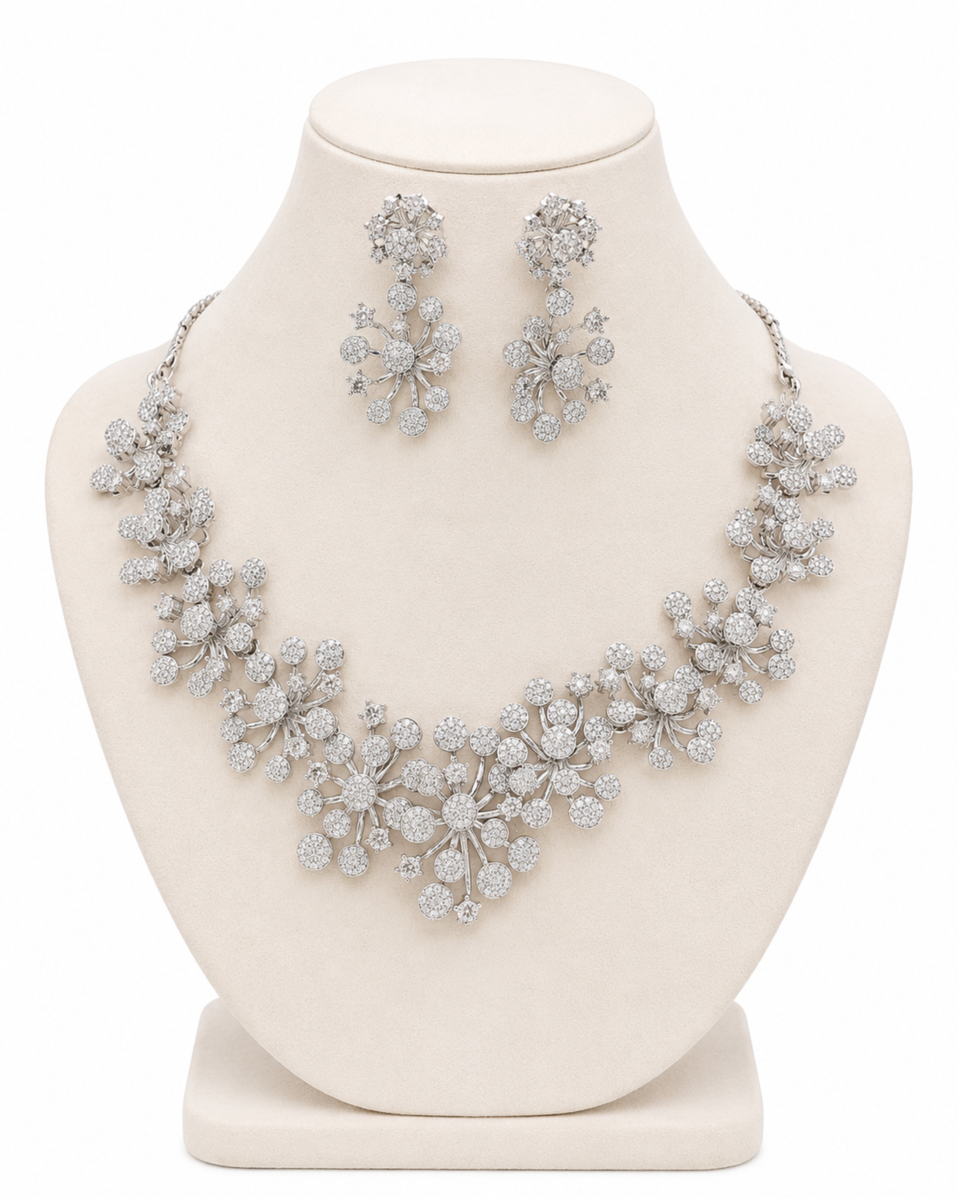 Silver necklace and earrings set on a mannequin bust against a white background