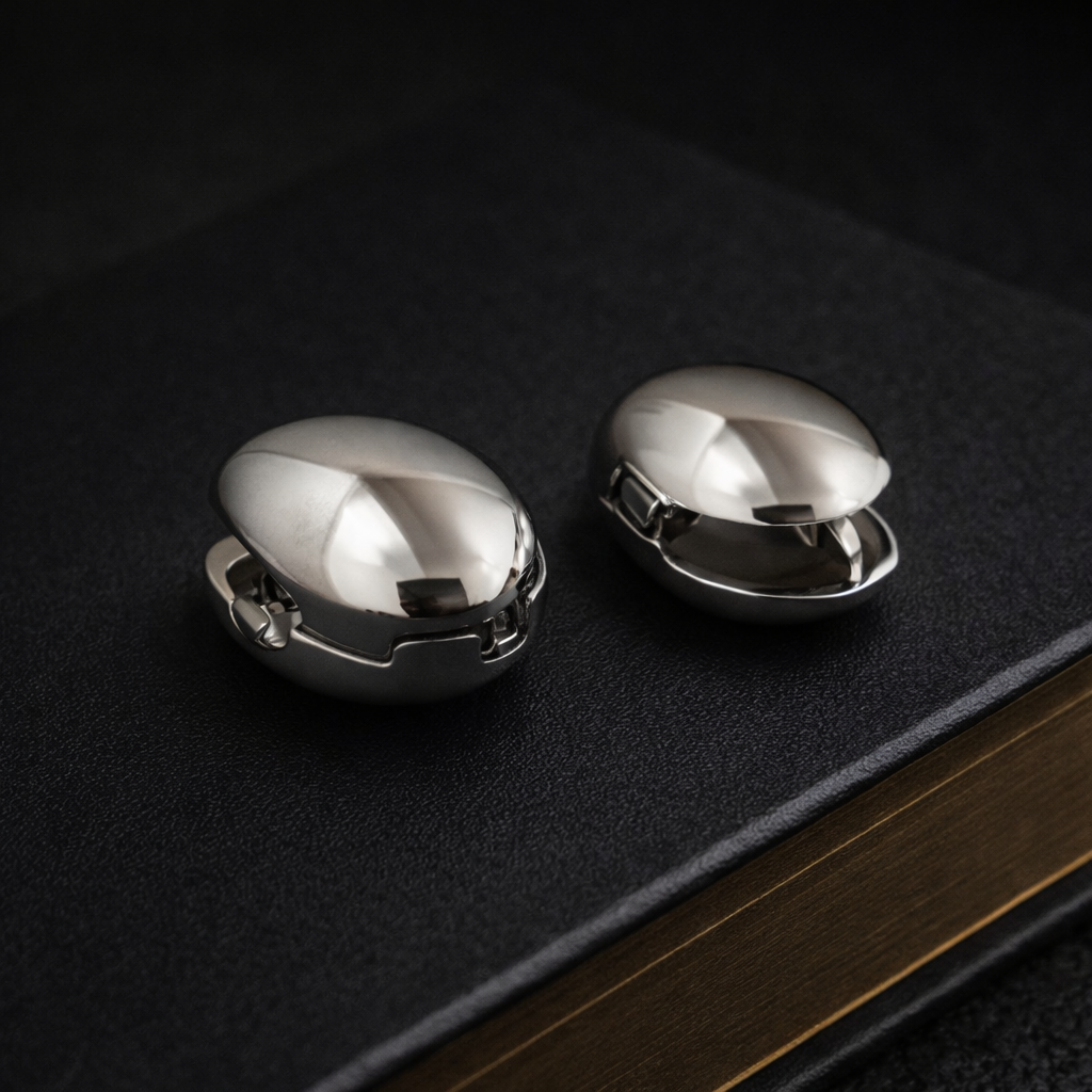 Two metallic objects on a textured black surface