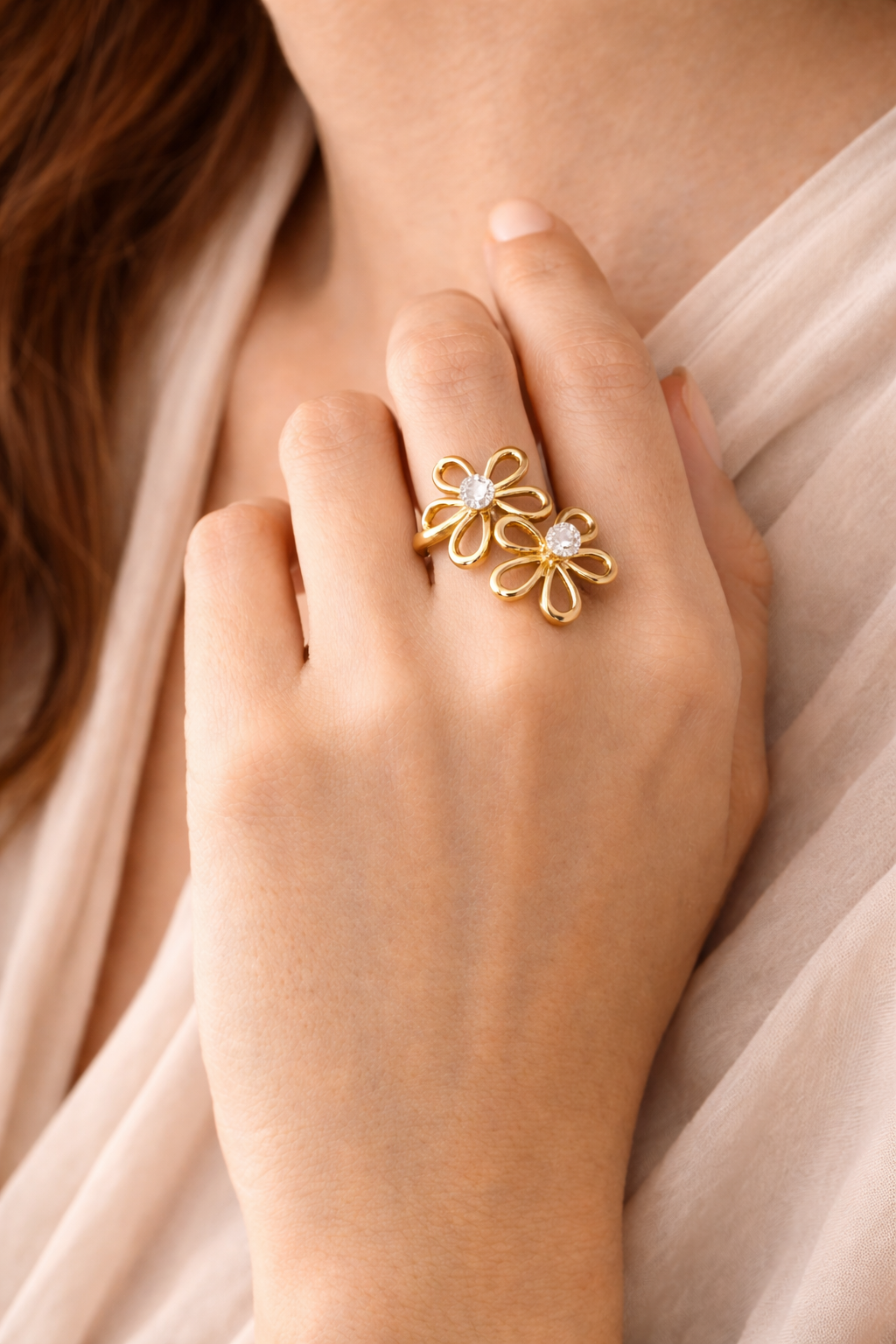 Gold floral ring on a hand with a soft background