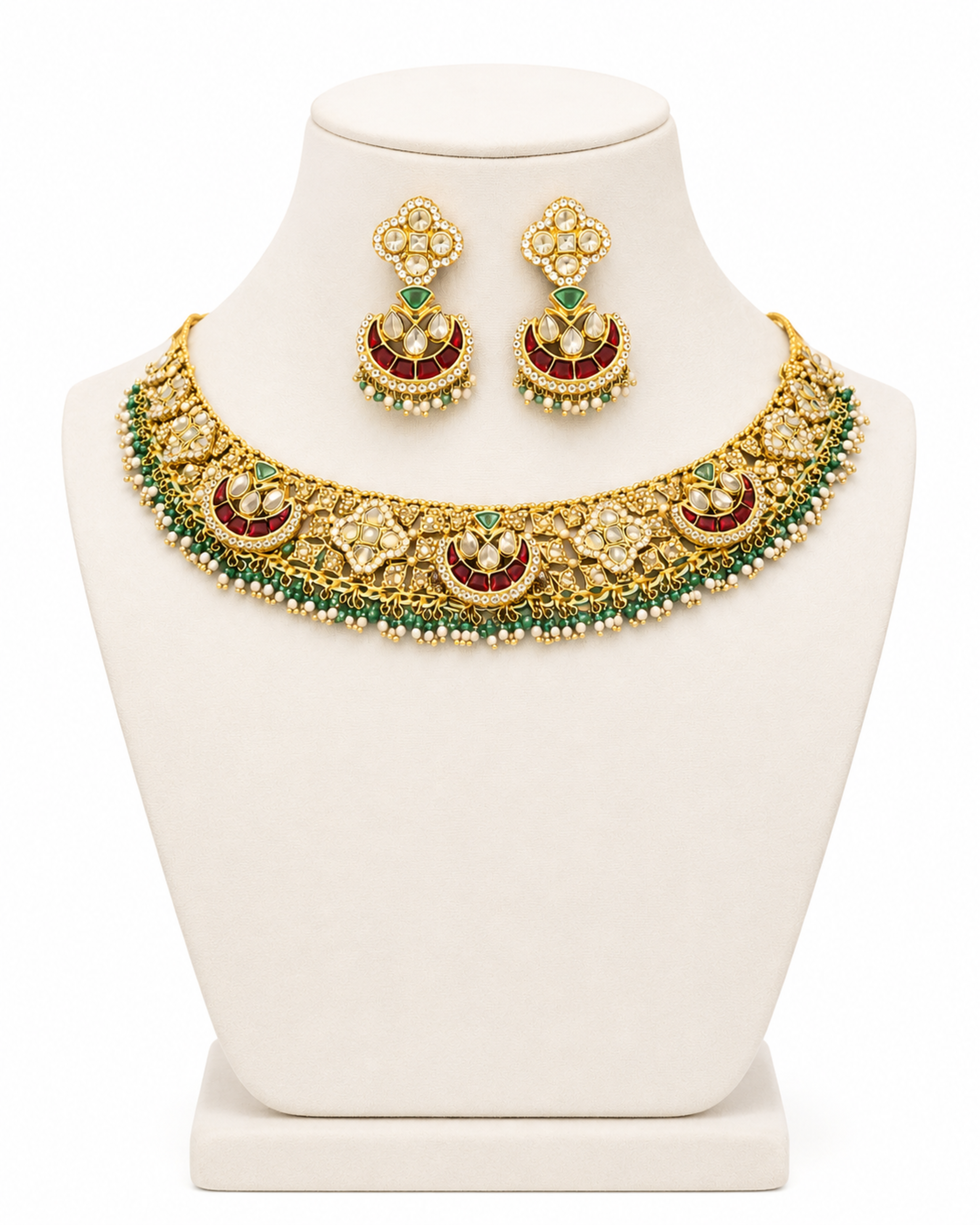 Gold necklace with green and red stones on a mannequin bust