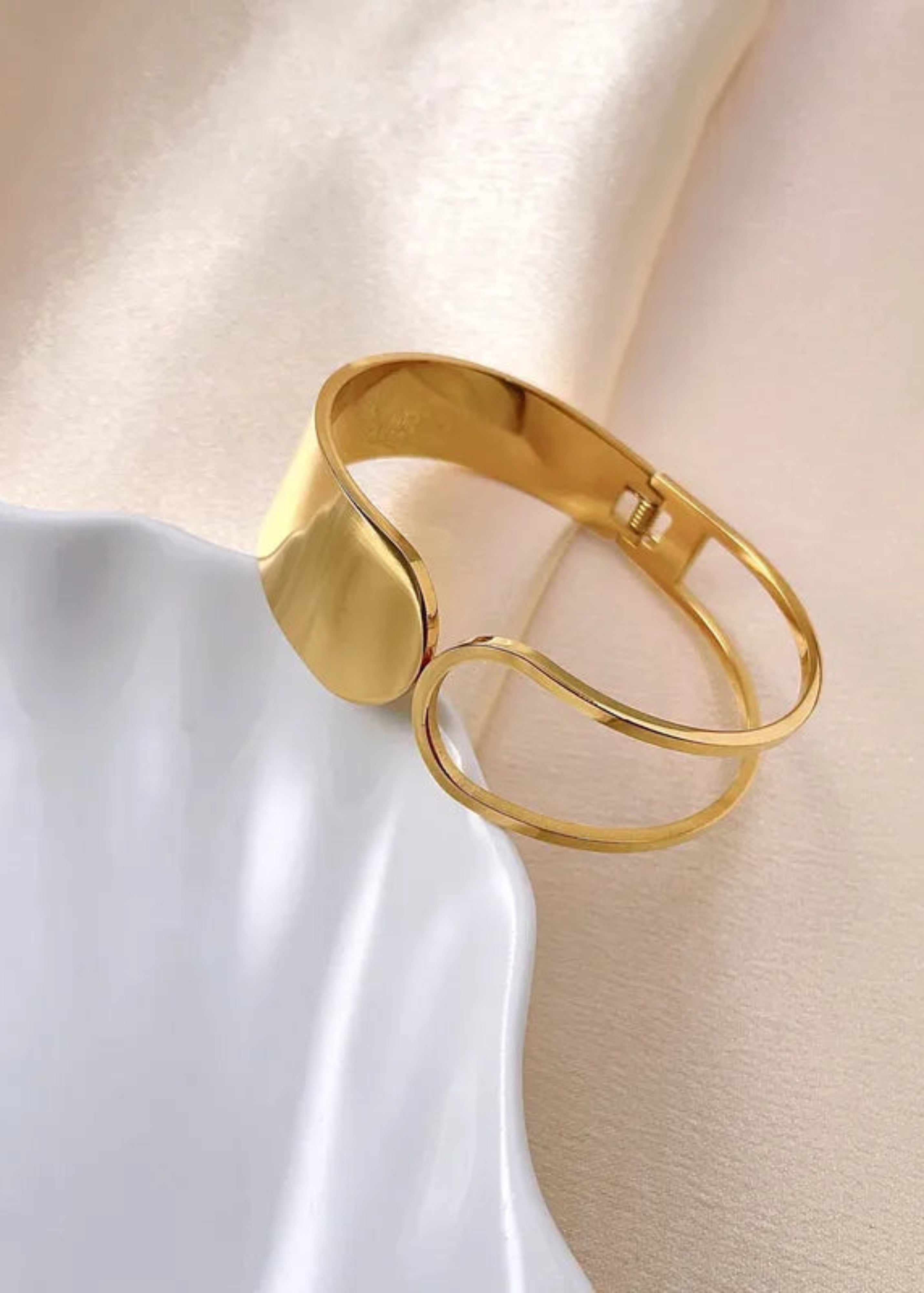 Gold bracelet on a soft fabric background