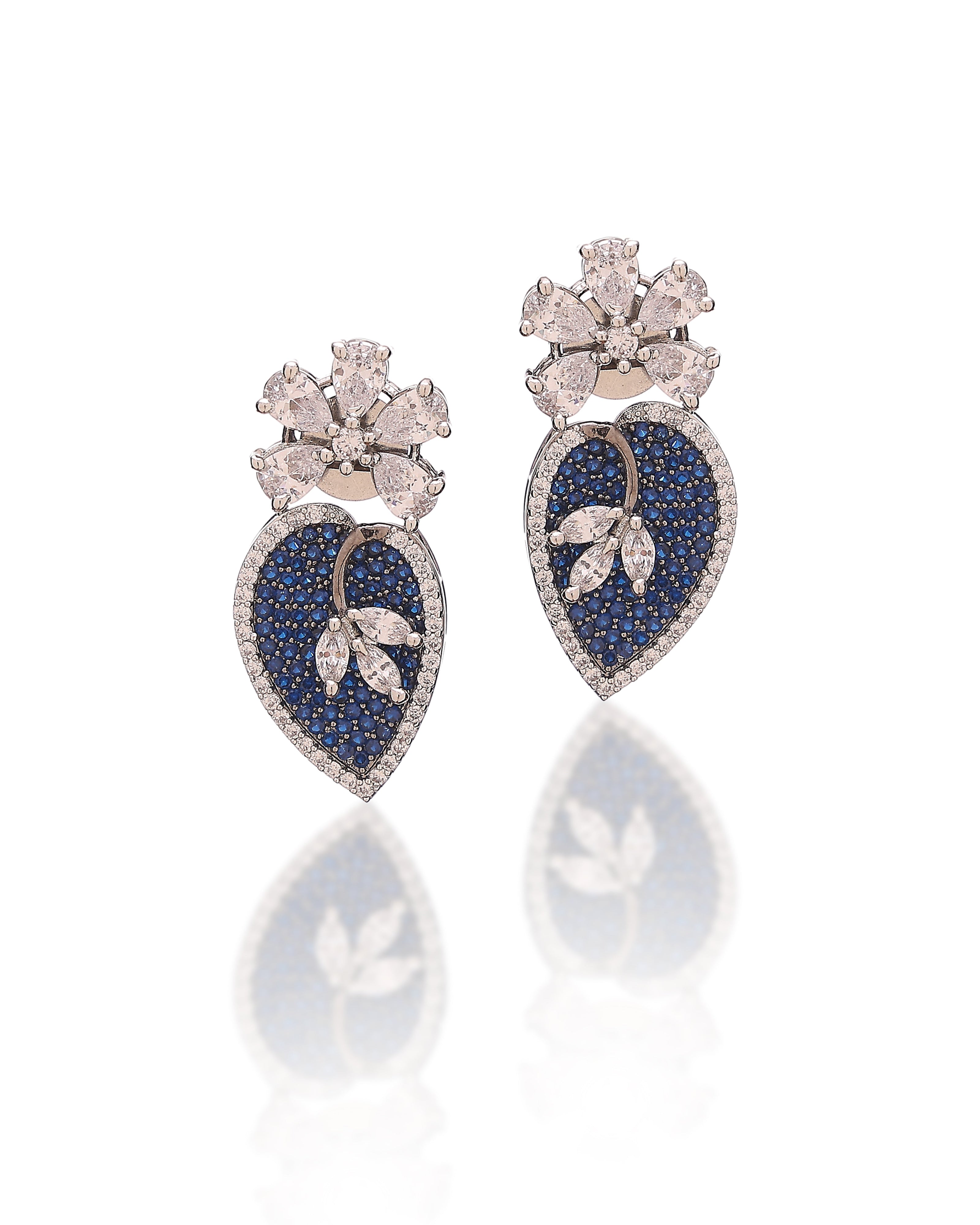 Pair of heart-shaped earrings with blue gemstones and floral designs on a white background