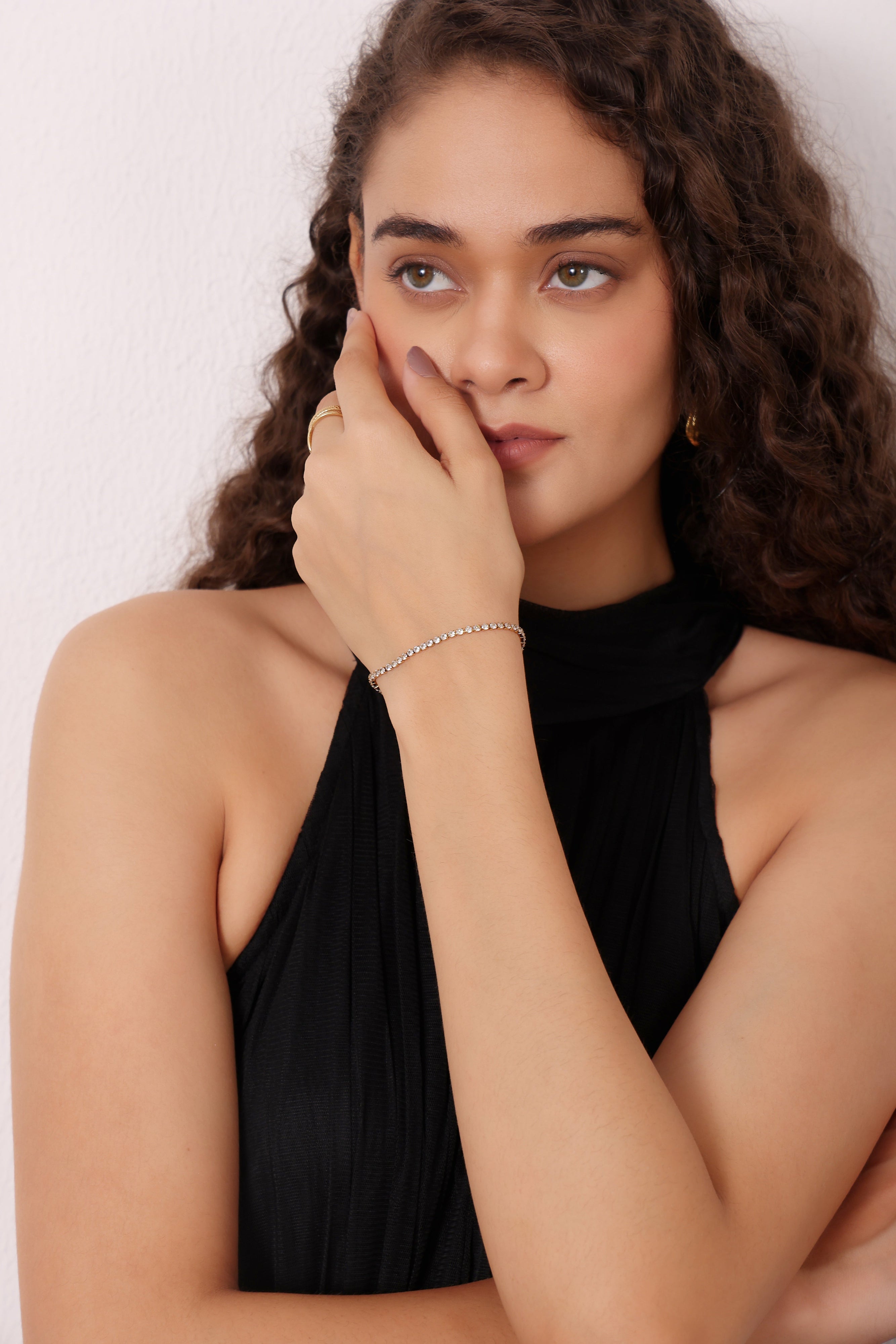 Woman wearing a black halter top with a plain background