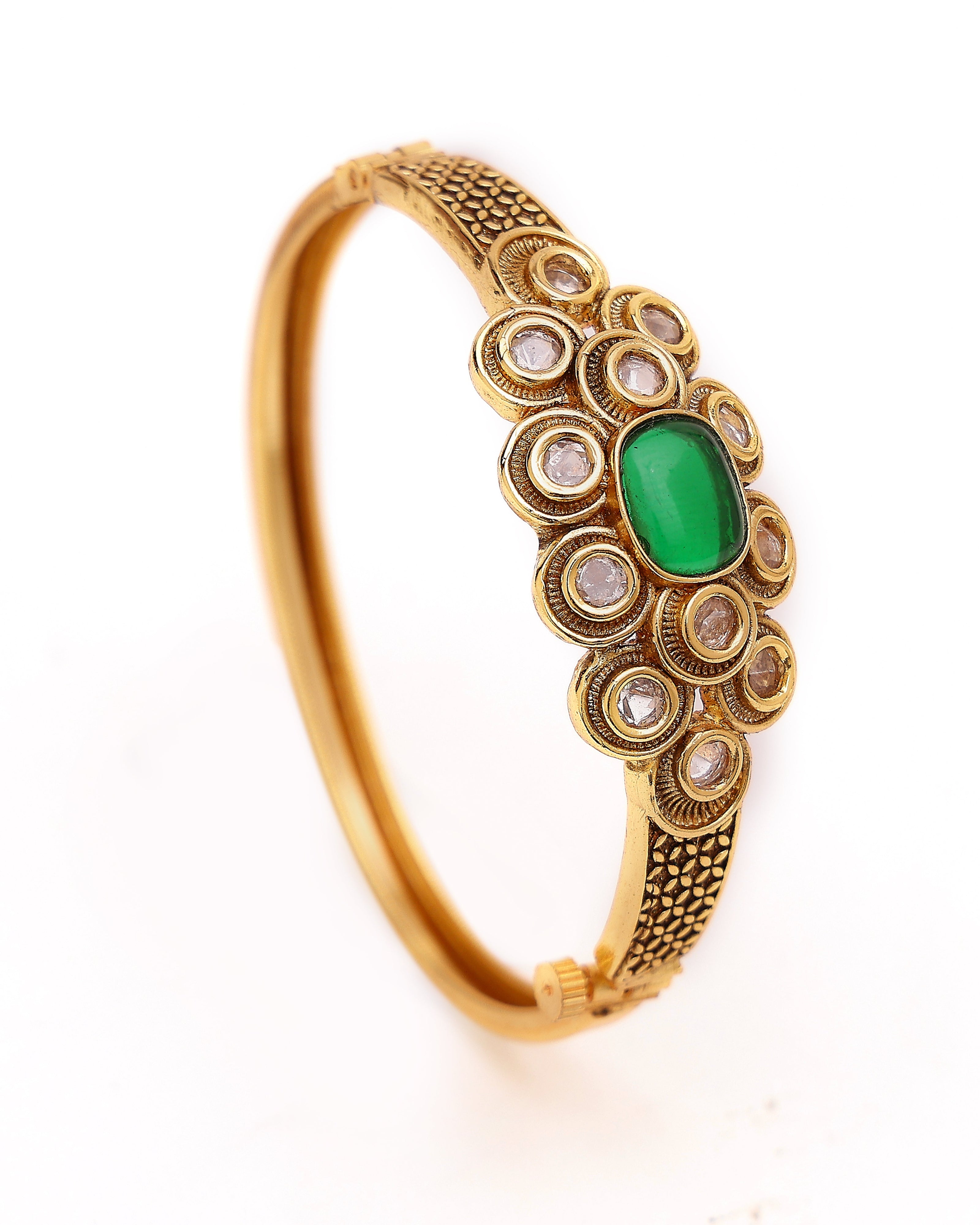 Gold bracelet with a green gemstone on a white background