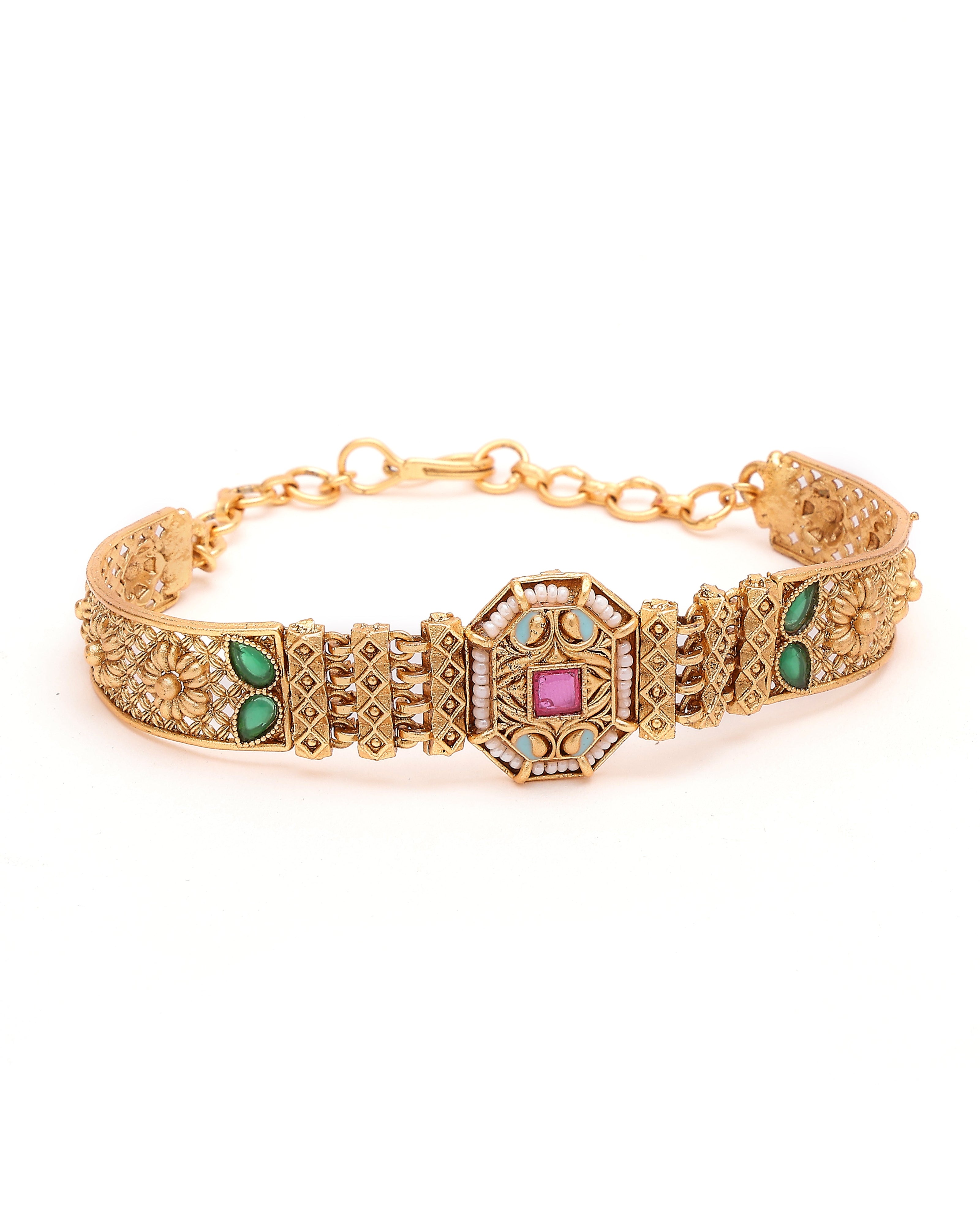 Gold bracelet with gemstone accents on a white background