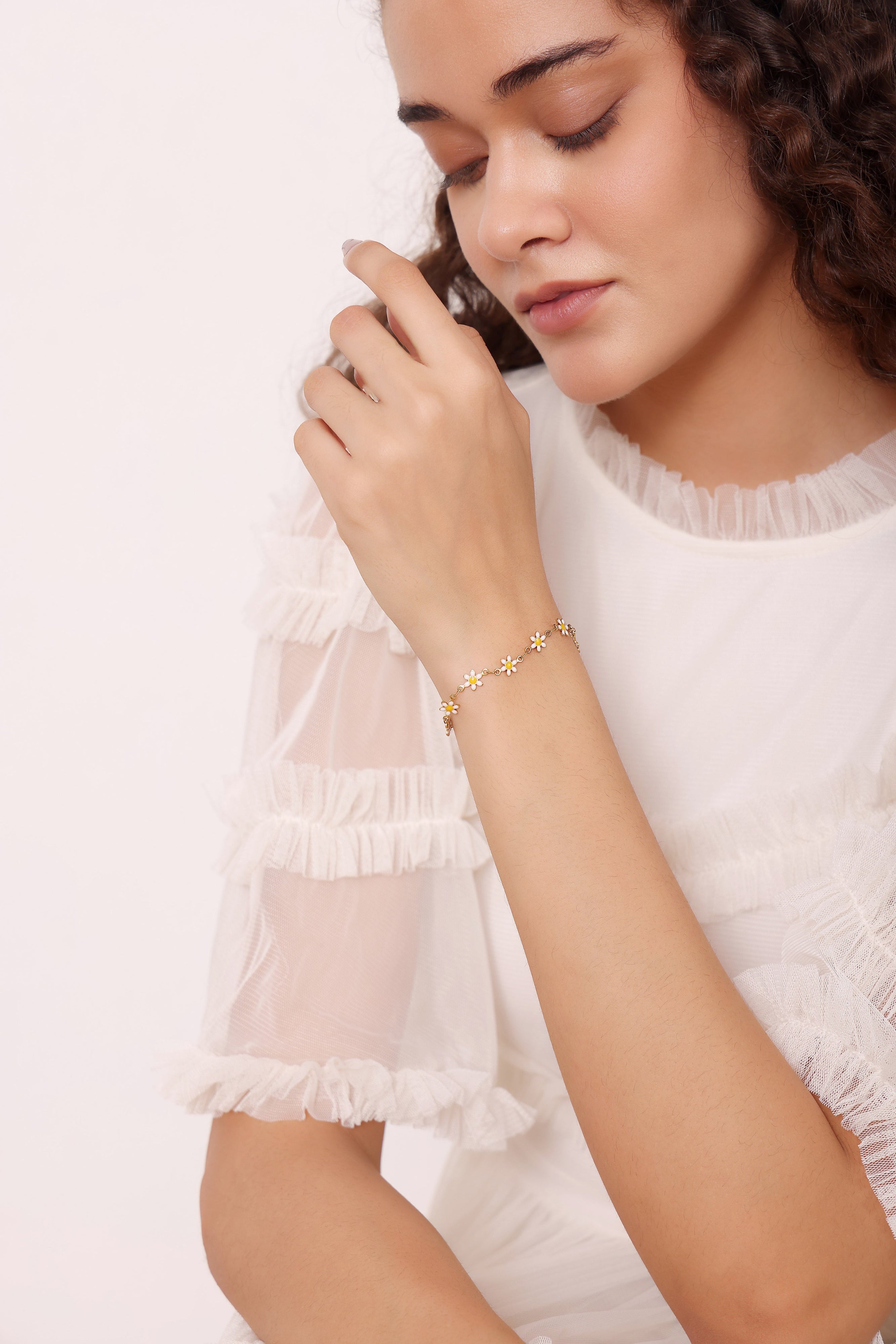 Woman wearing a delicate bracelet with a subtle design on a plain background