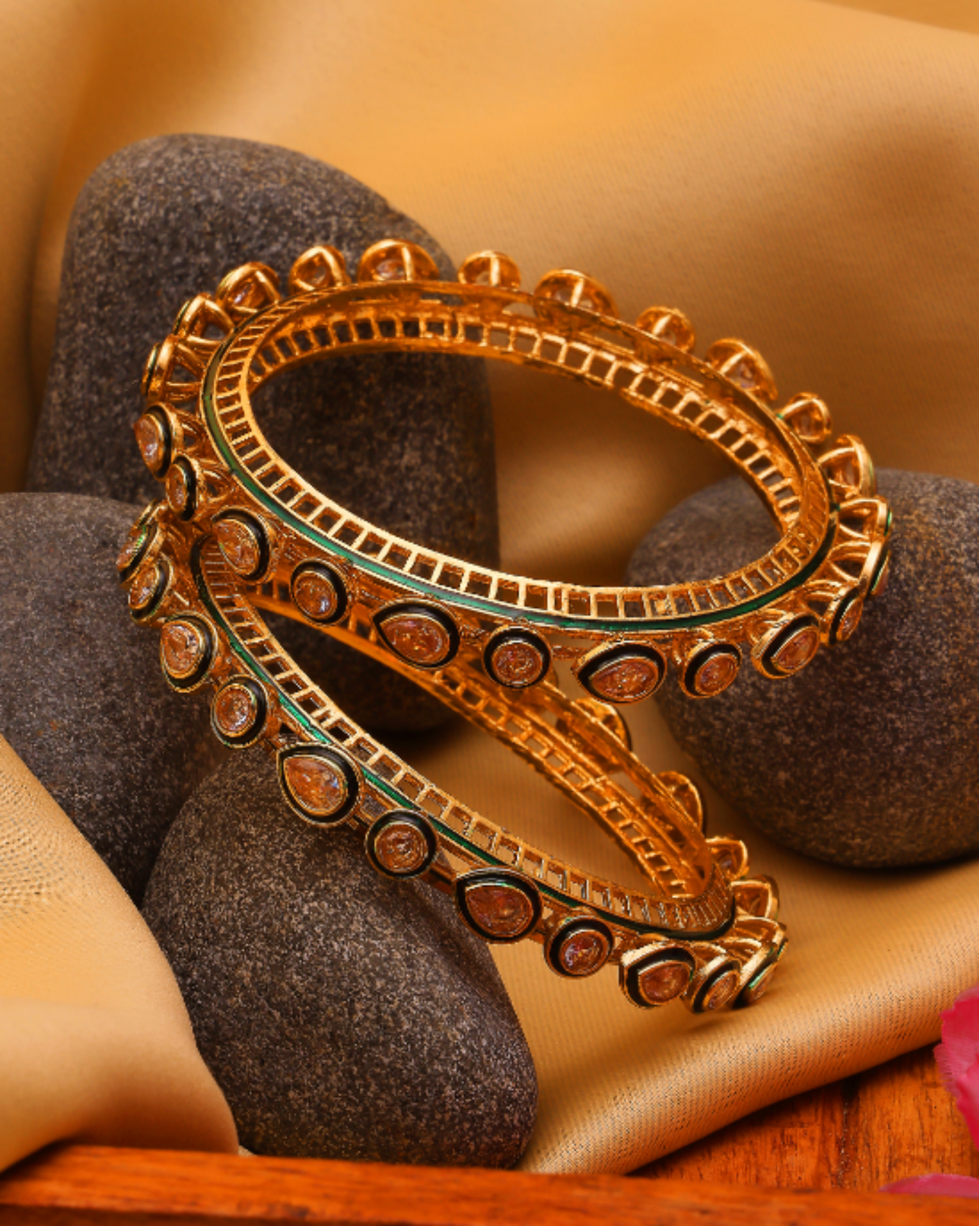 Decorative gold bangles on a textured surface