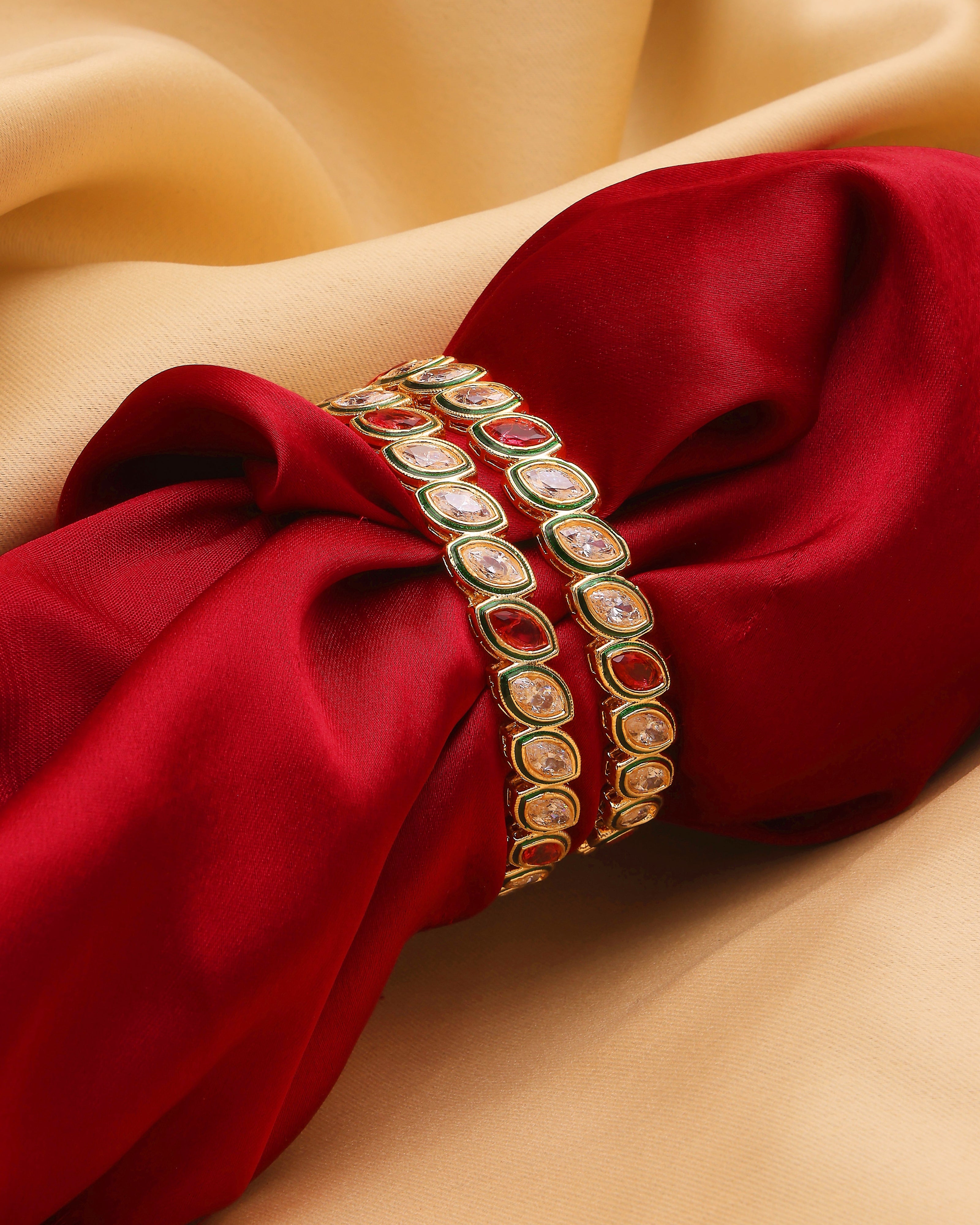 Decorative bangles on a red fabric with a beige background
