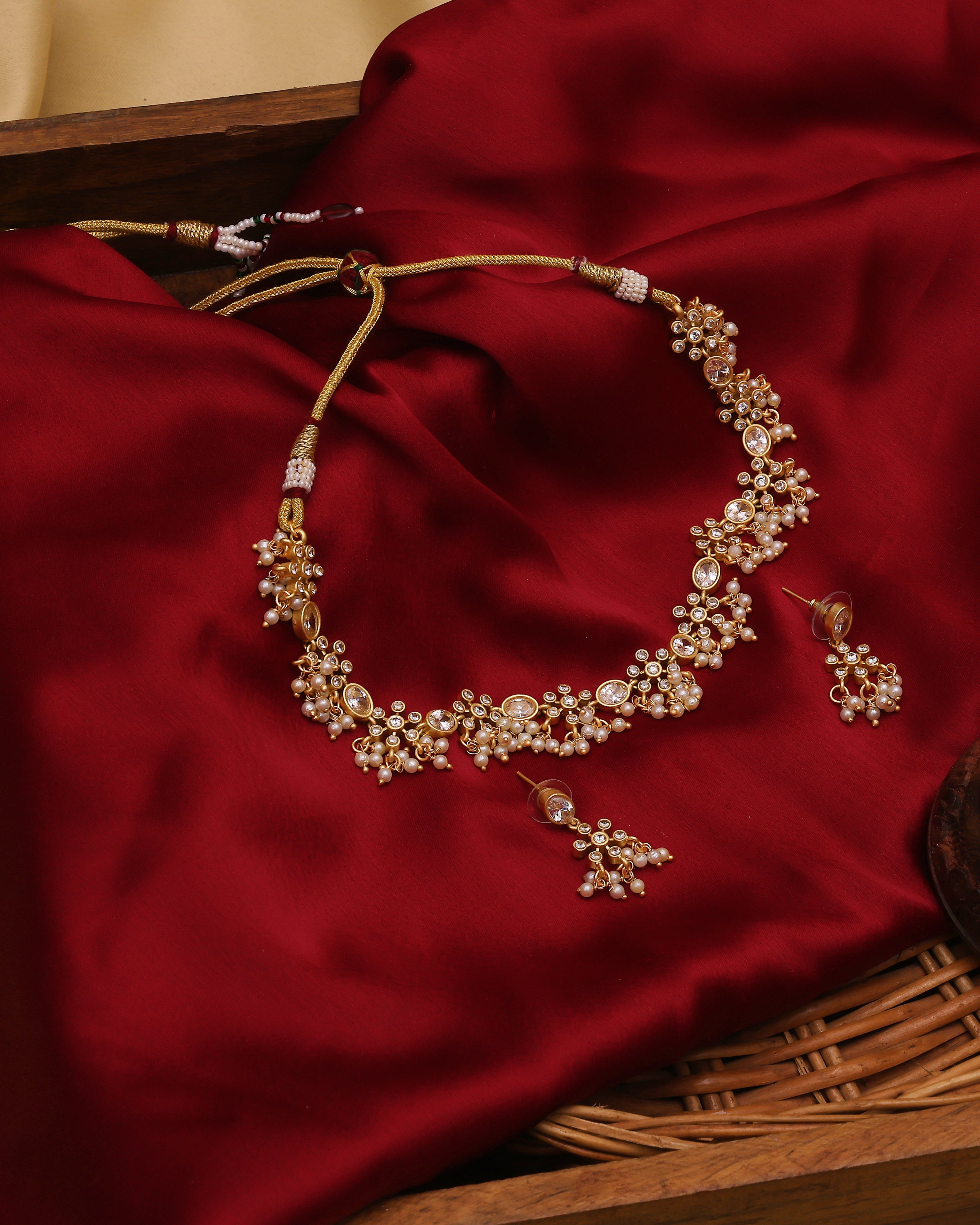 Gold necklace with floral design on a red fabric background