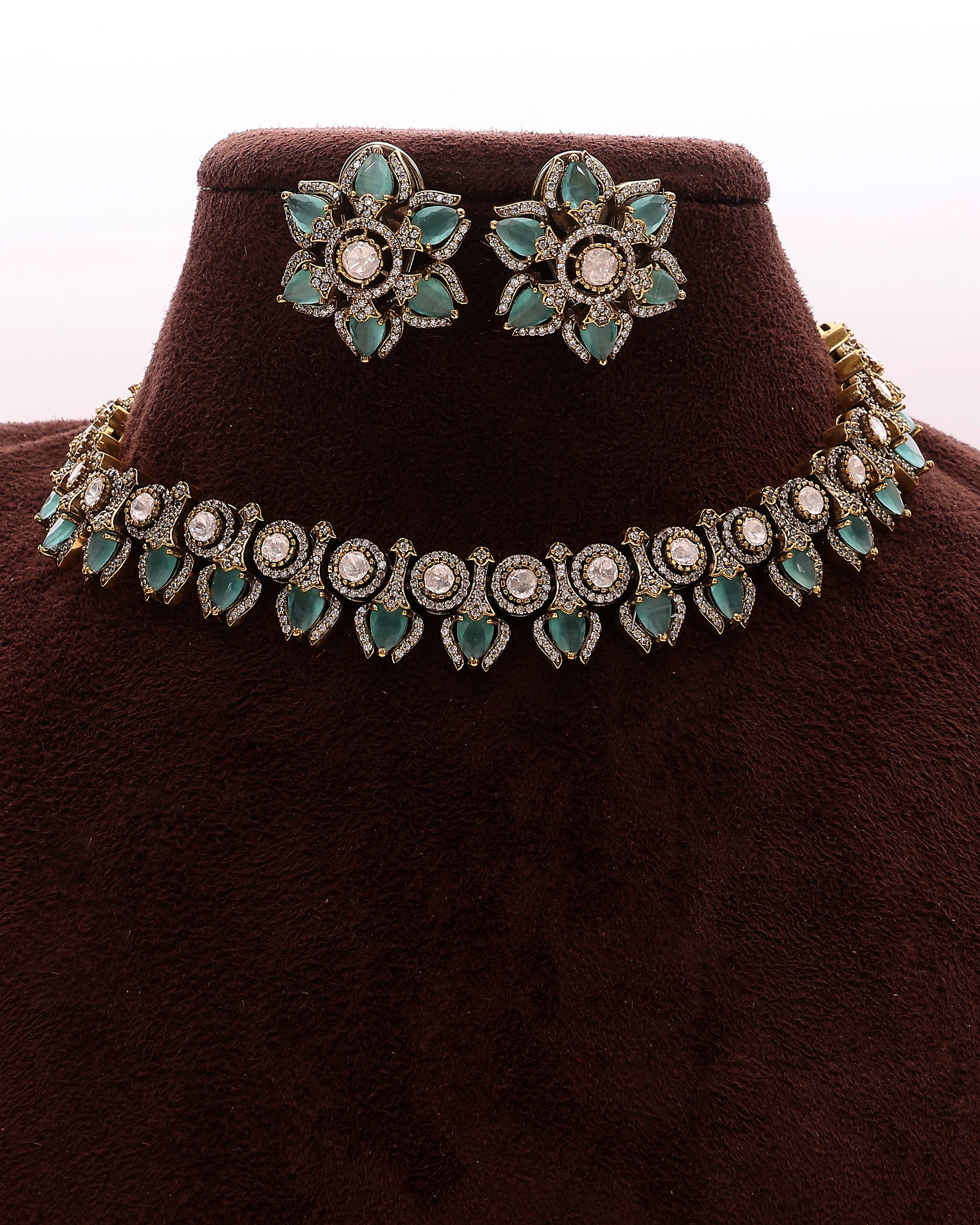 Jewelry set with necklace and earrings on a brown velvet stand