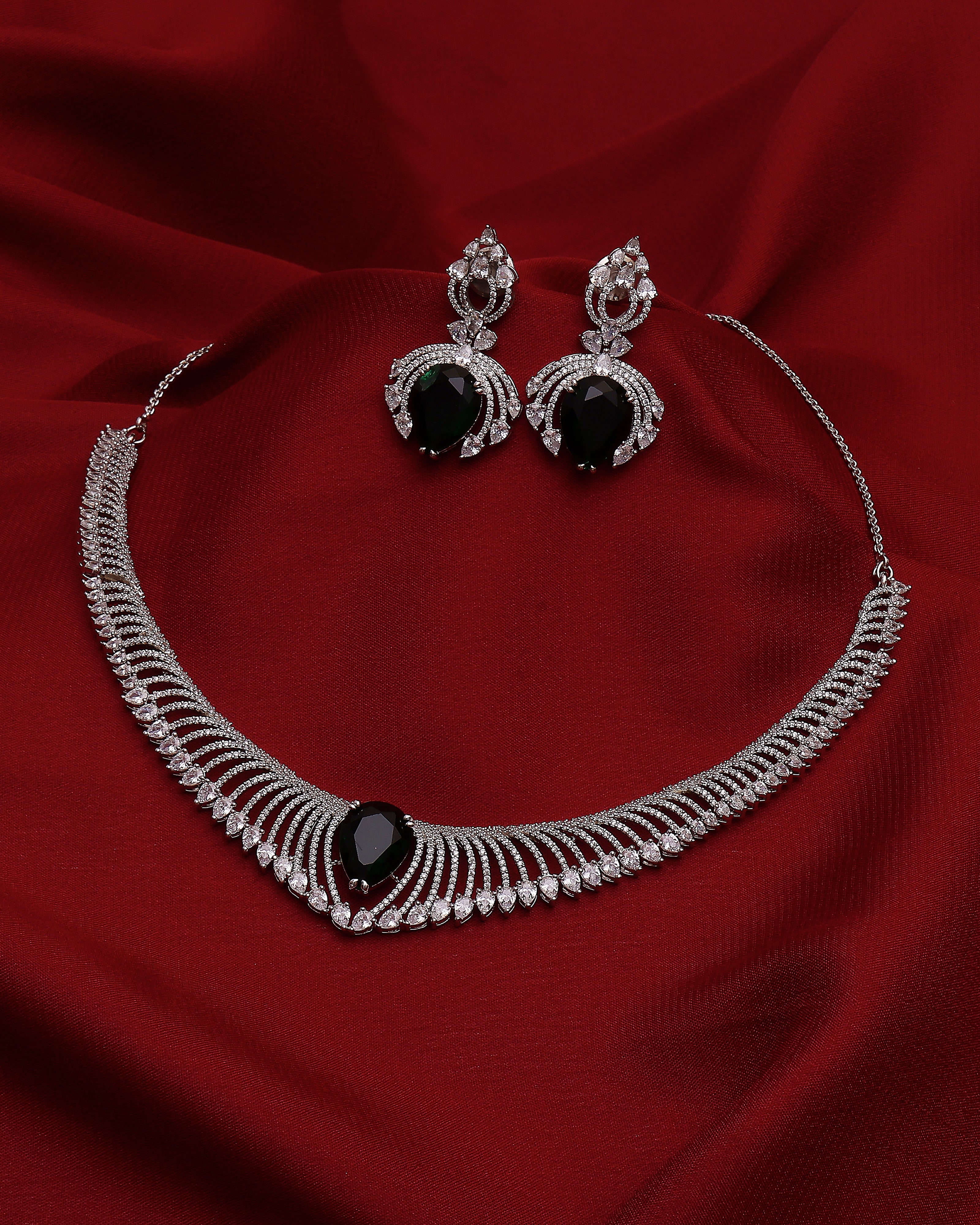 Jewelry set with necklace and earrings on a red fabric background