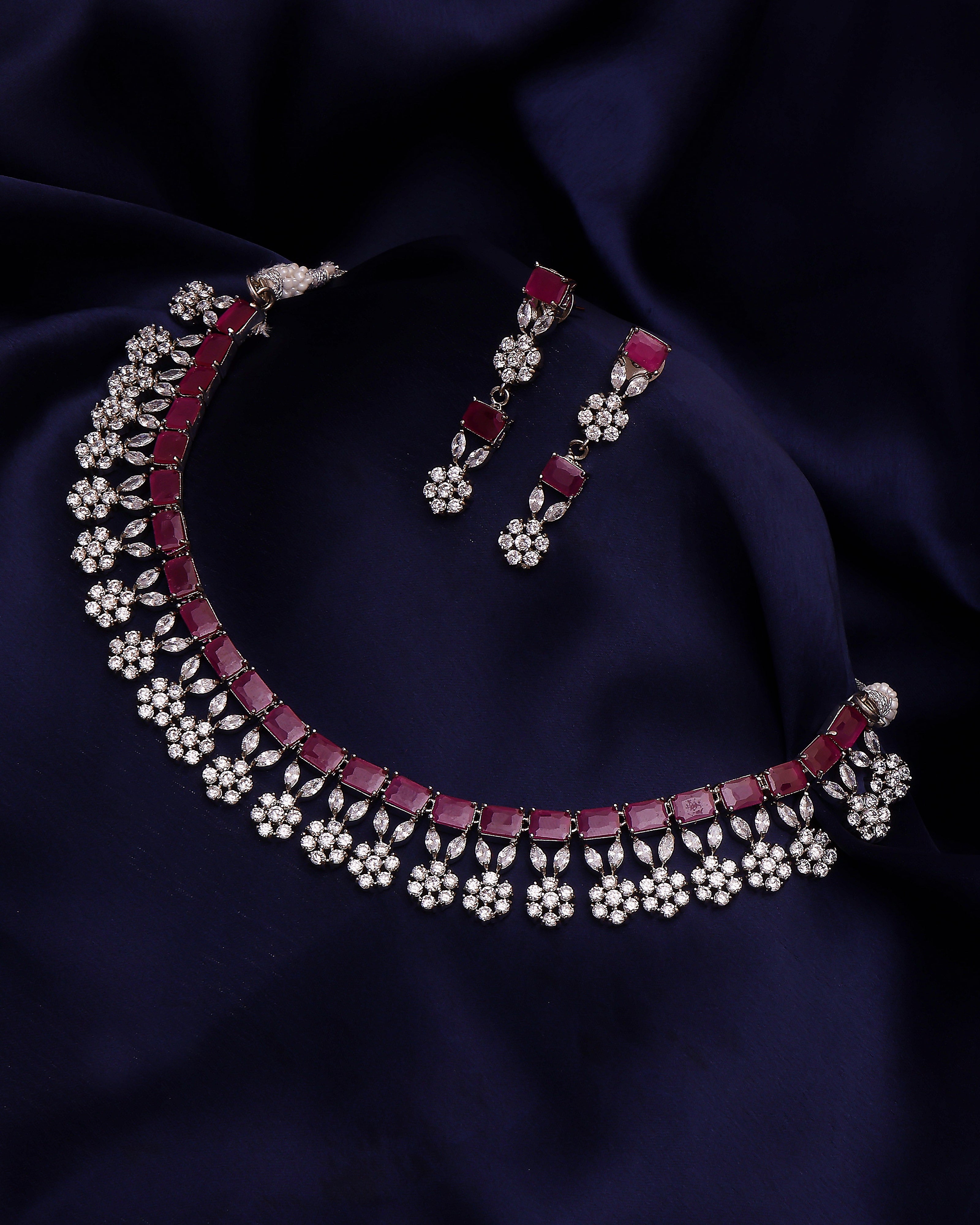 Jewelry set with necklace and earrings on a dark blue fabric background