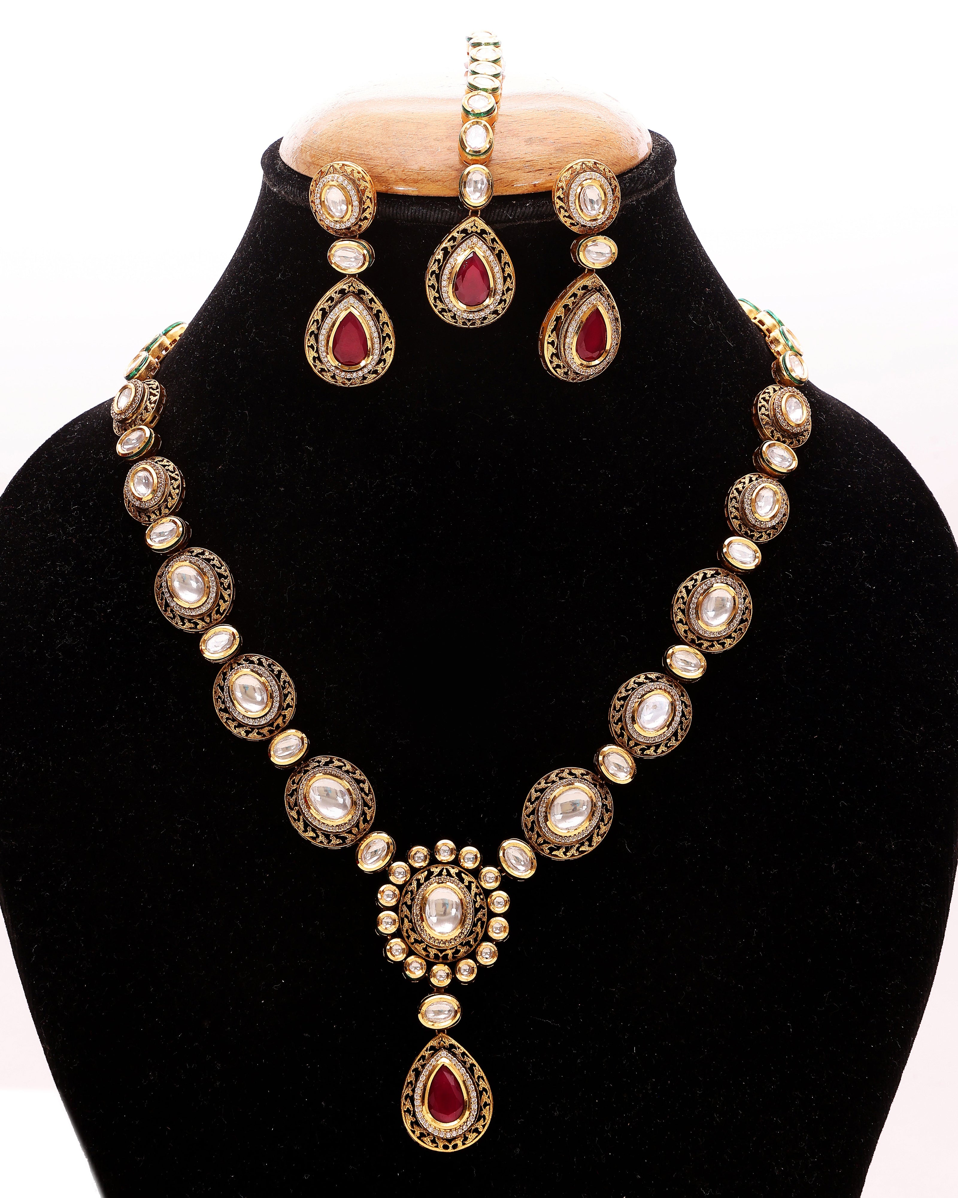 Jewelry set with necklace and earrings on a black stand