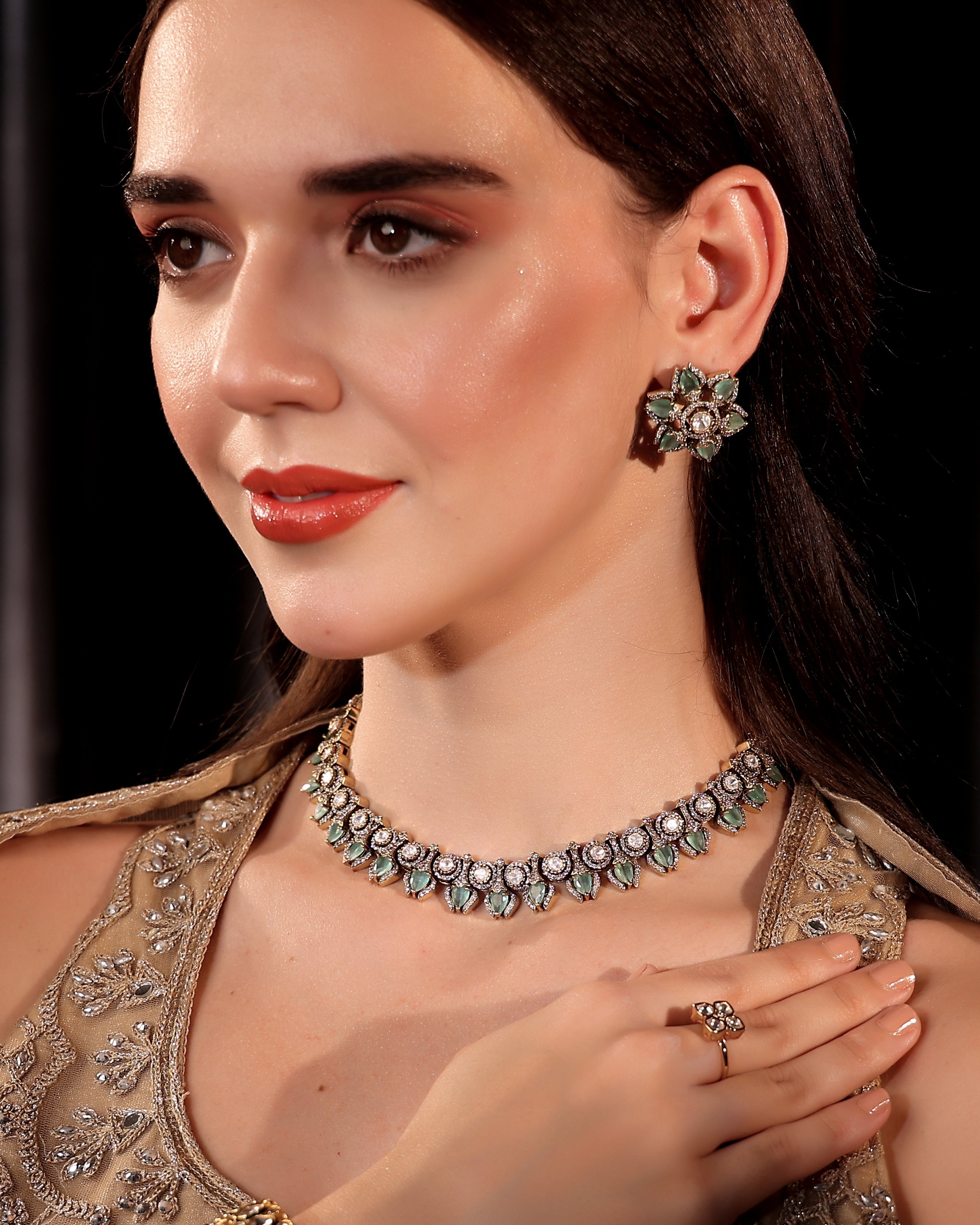 Woman wearing an ornate necklace and earrings with a dark background