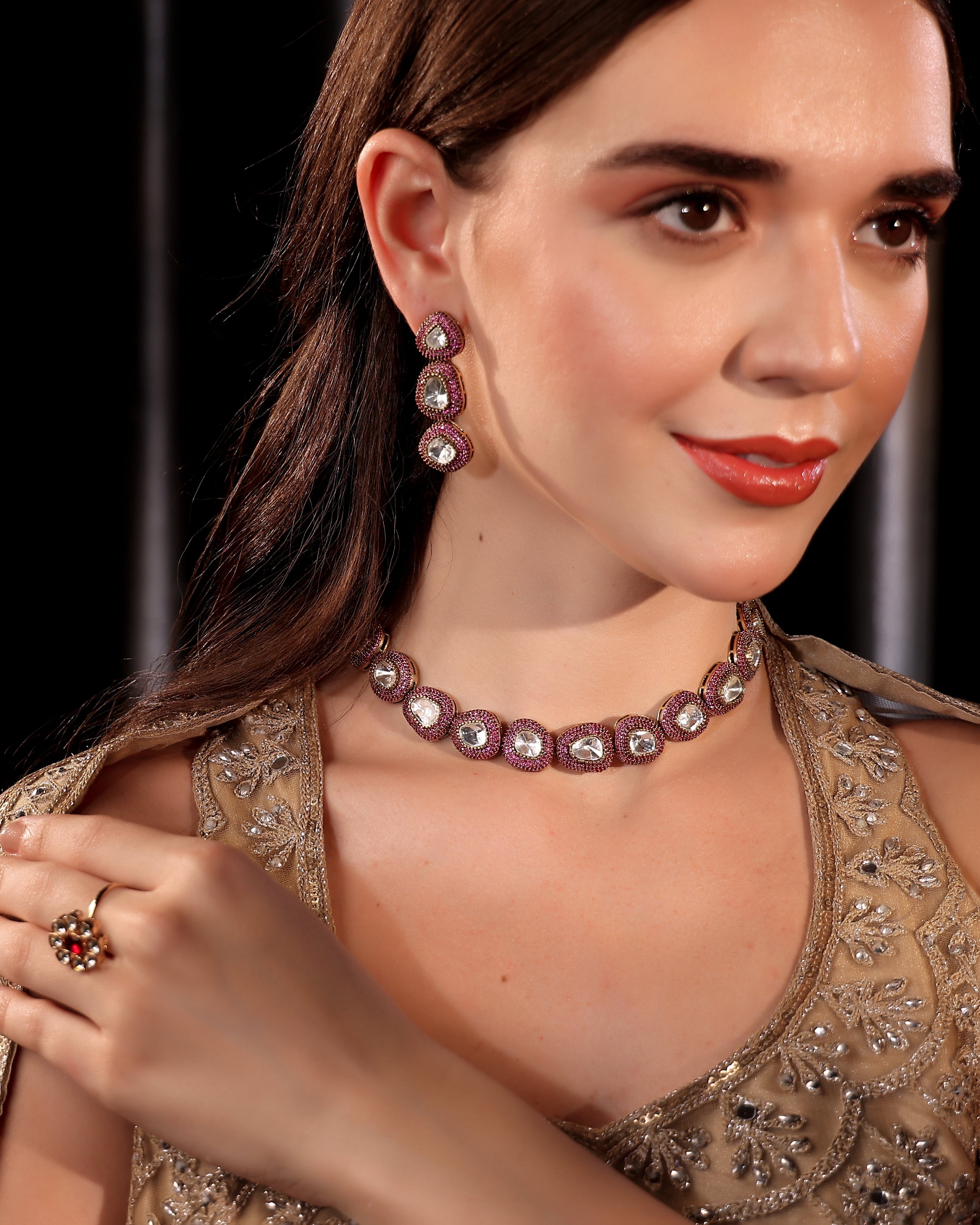 Woman wearing a necklace and earrings with a dark background