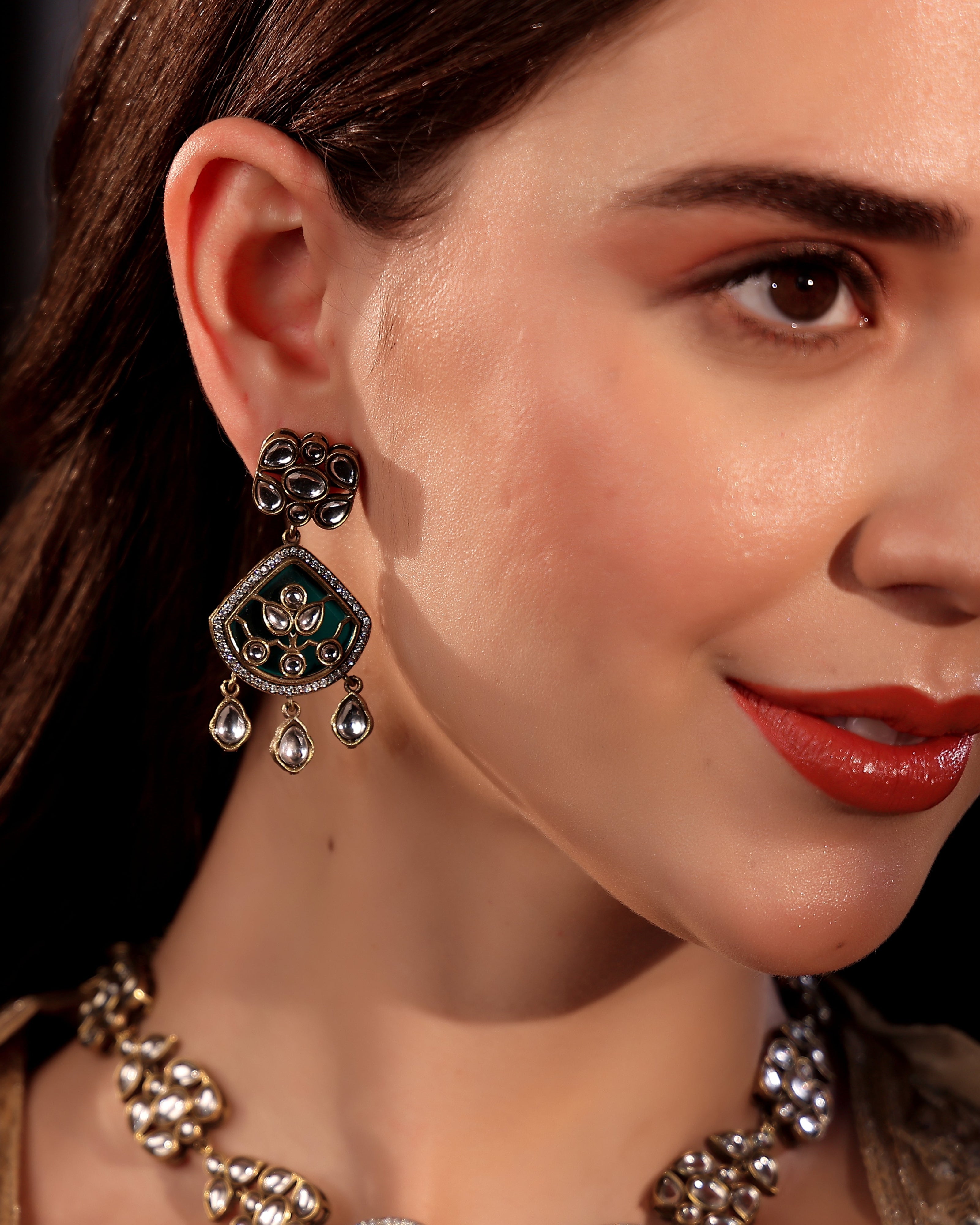 Close-up of a woman wearing ornate earrings and a necklace.