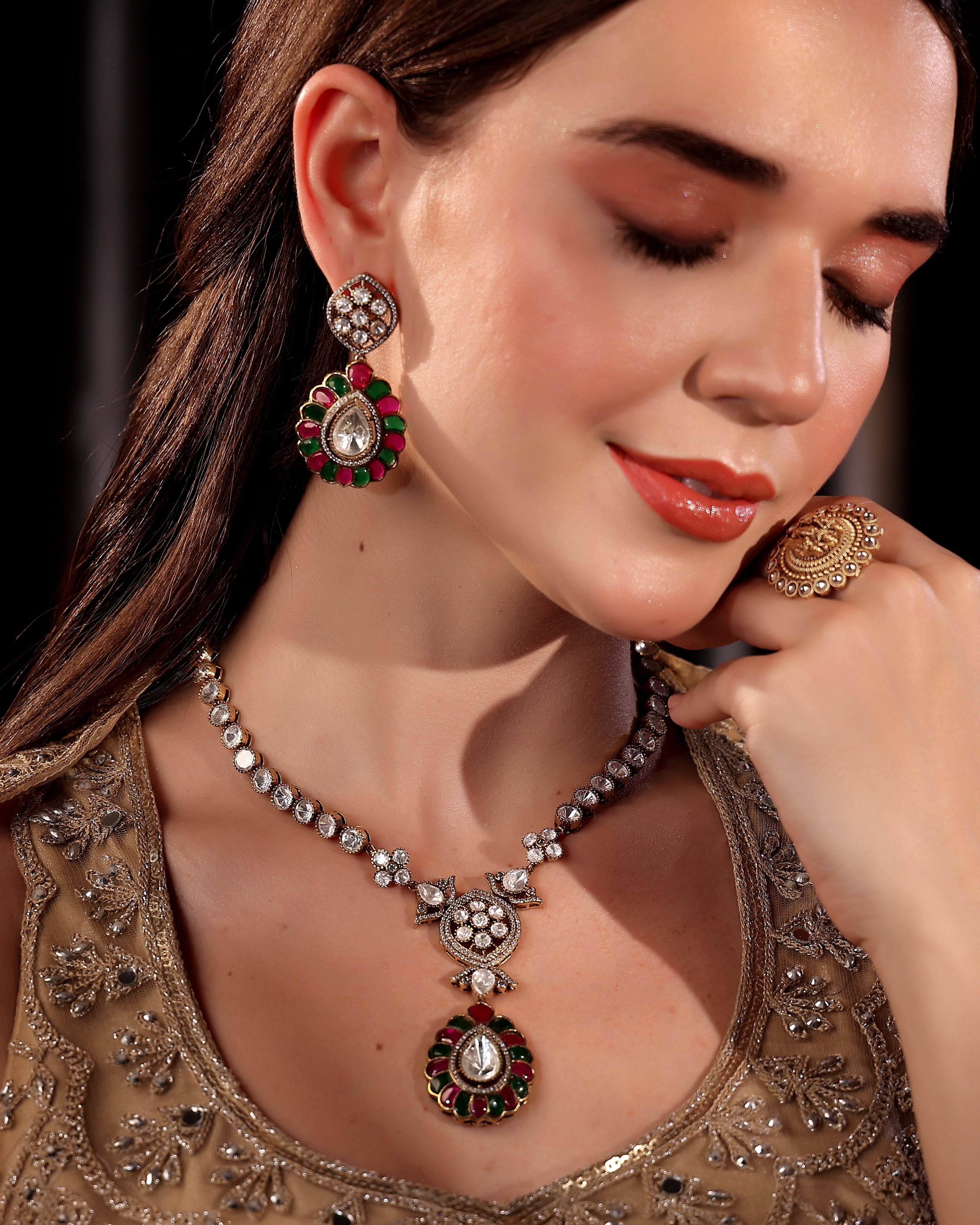 Woman wearing traditional jewelry including a necklace, earrings, and ring.