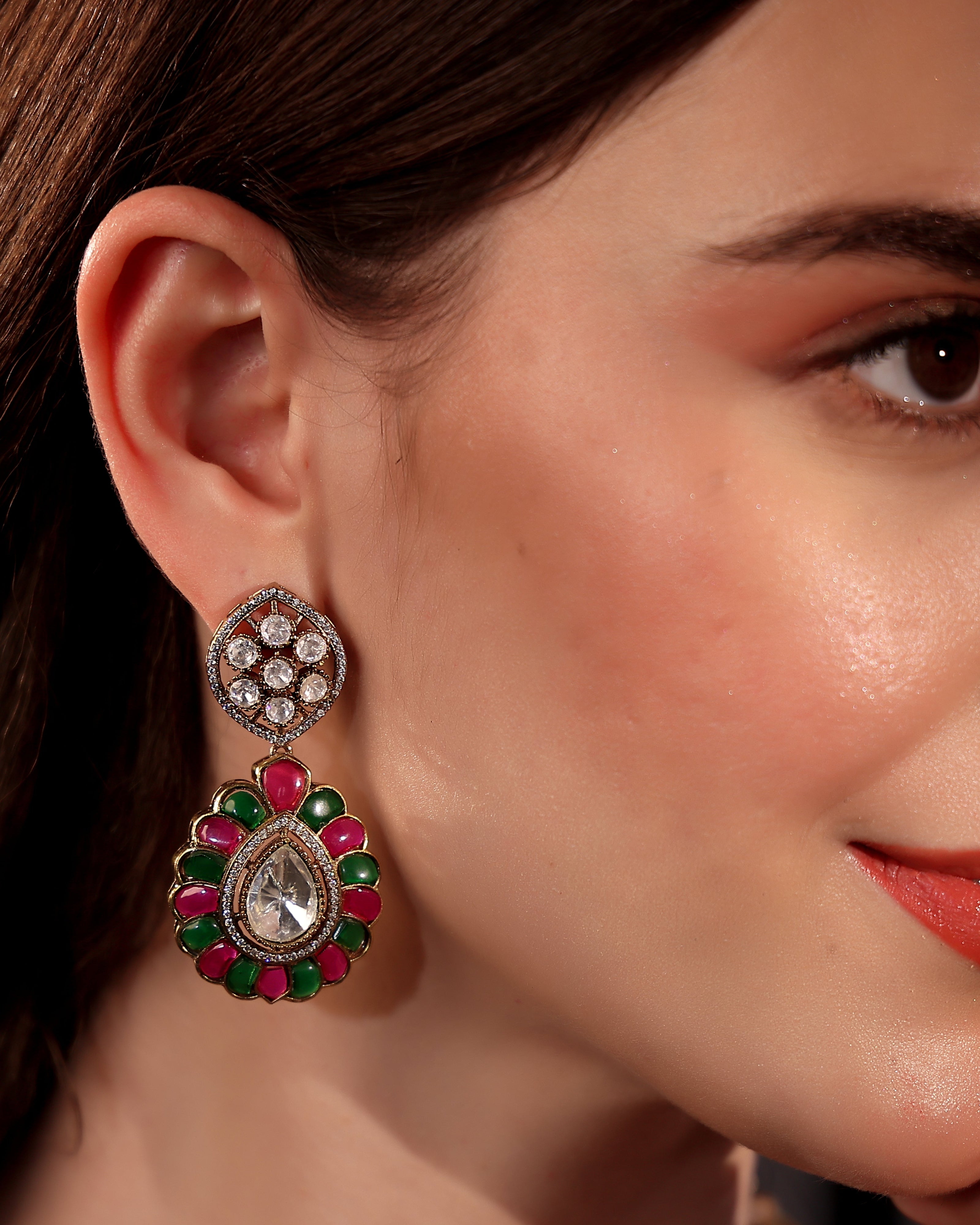 Close-up of a woman wearing a decorative earring with gemstones.