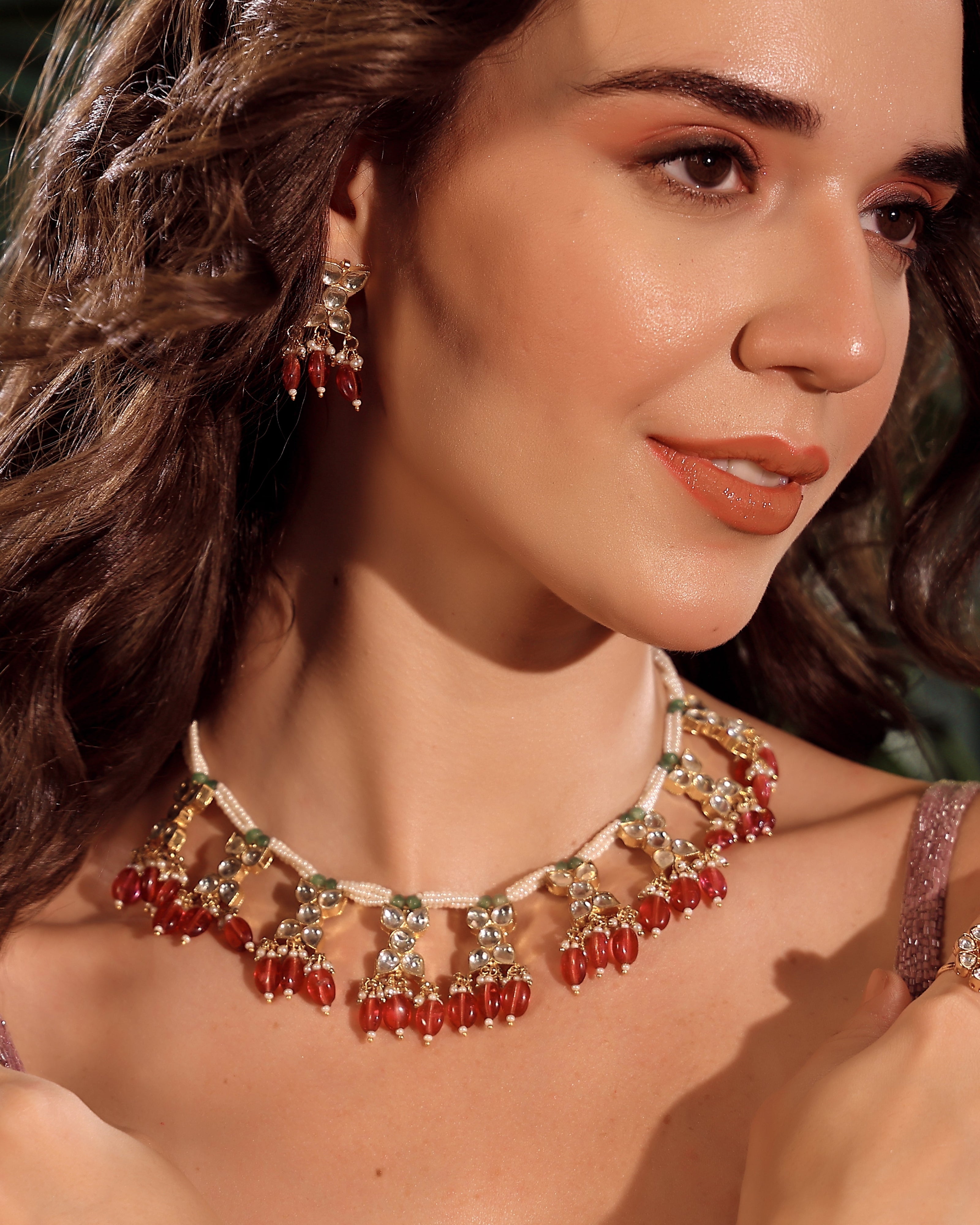 Woman wearing a necklace with red beads and gold accents