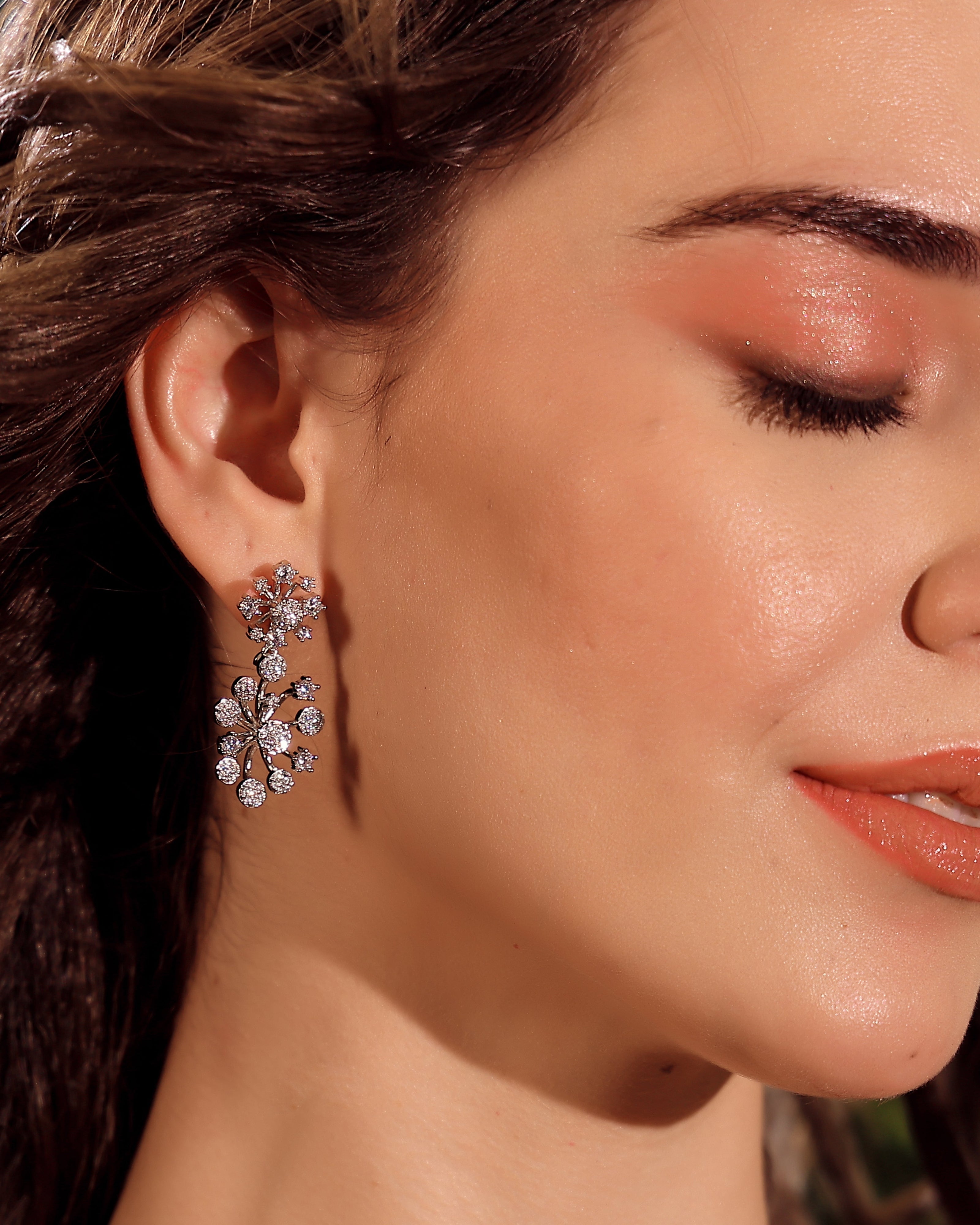Close-up of a woman wearing a floral earring with a blurred background