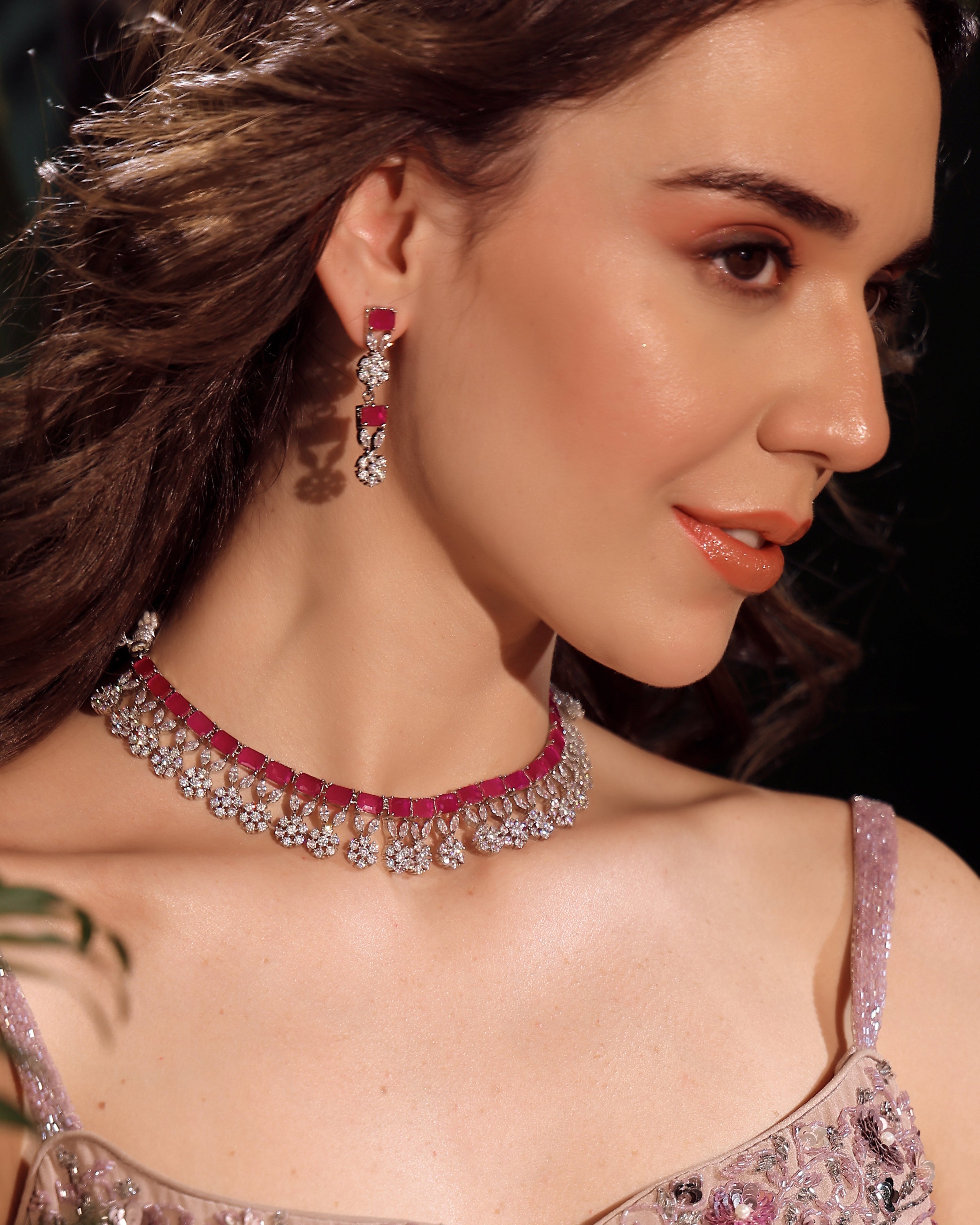 Woman wearing a necklace and earrings with a dark background